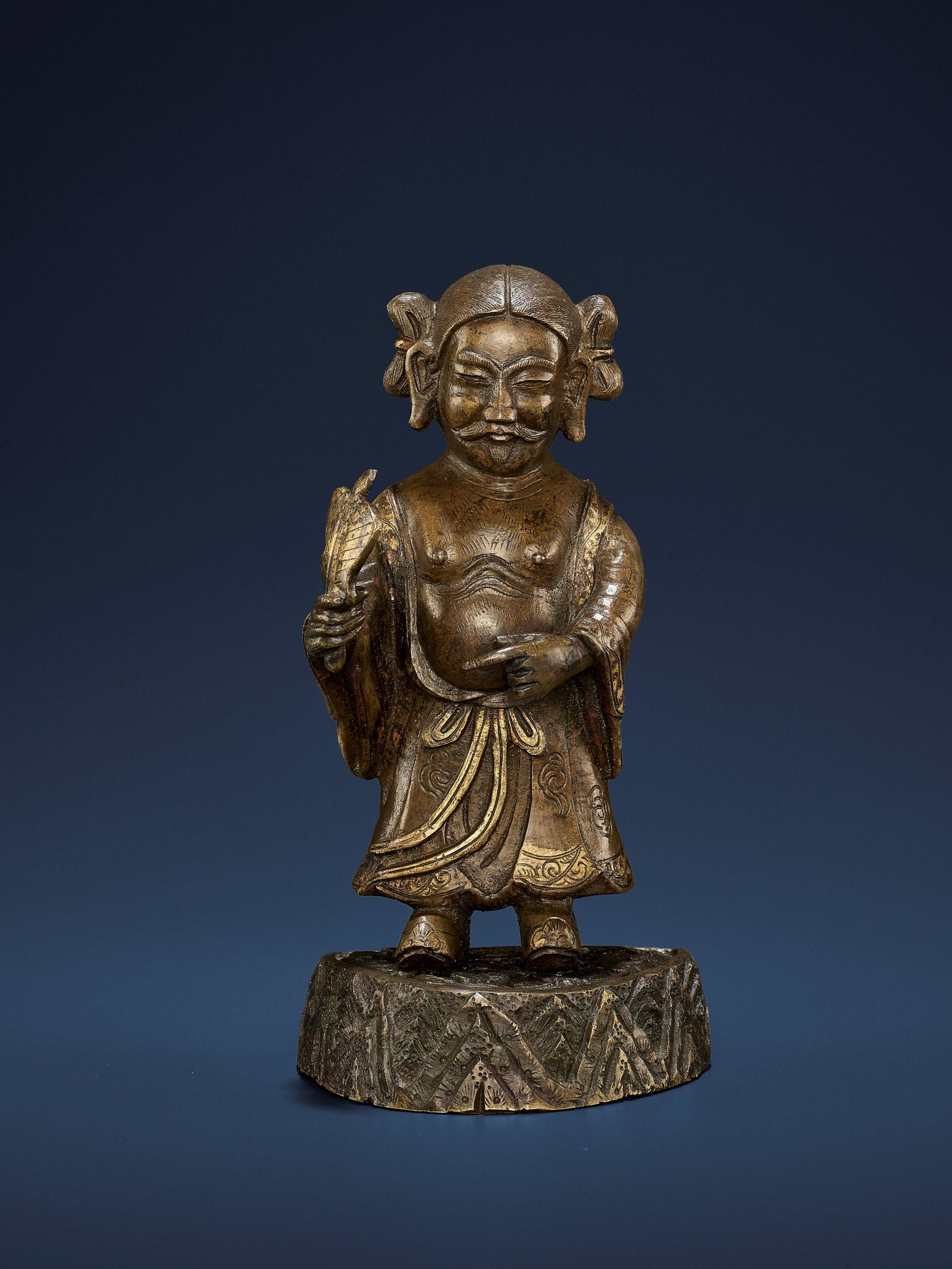 A PARCEL-GILT BRONZE OF HAN ZHONGLI, MING: A PARCEL-GILT BRONZE OF HAN ZHONGLI, MING China, 1368-1644. The immortal's face is flanked by long ears and shows a charming, amused expression with his eyes nearly closed and the lips forming a subtl