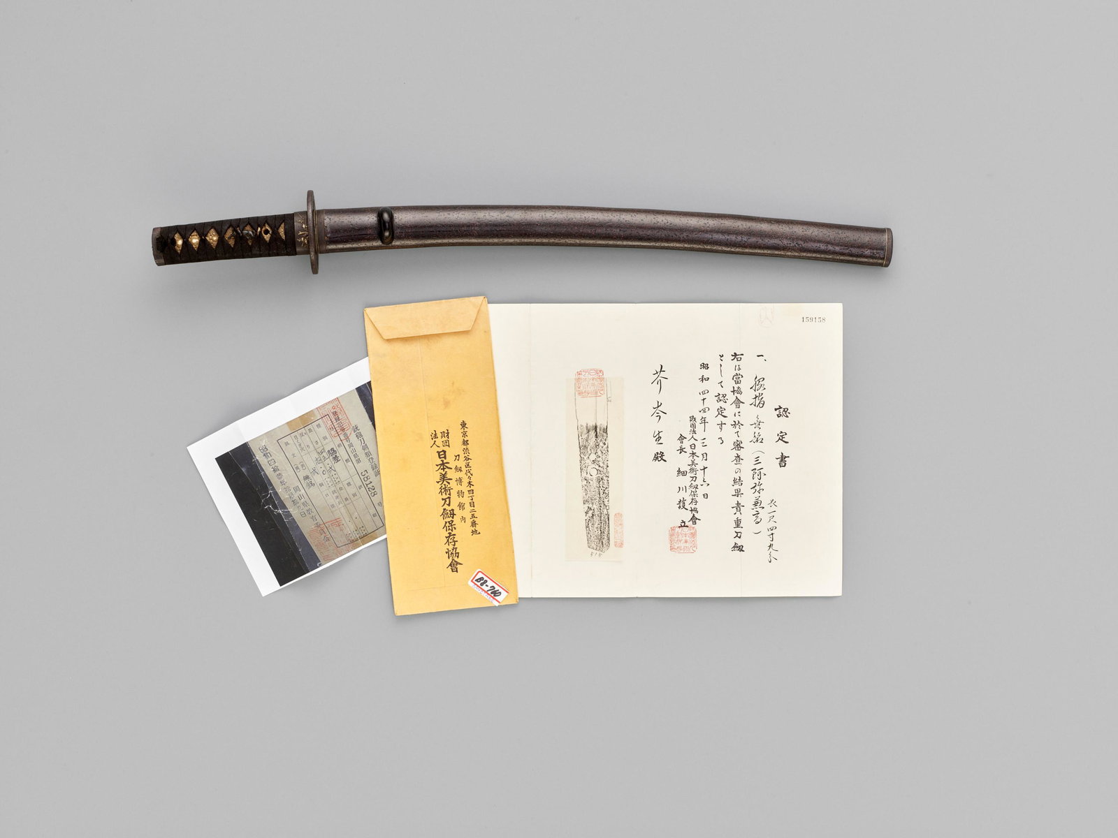 A WAKIZASHI IN KOSHIRAE WITH NBTHK CERTIFICATE: A WAKIZASHI IN KOSHIRAE, THE BLADE ATTRIBUTED TO SAN'AMI KANETAKA, WITH NBTHK CERTIFICATE By San'ami Kanetaka, unsigned Japan, 17th century, early Edo period (1615-1868) The blade: The gently curved b