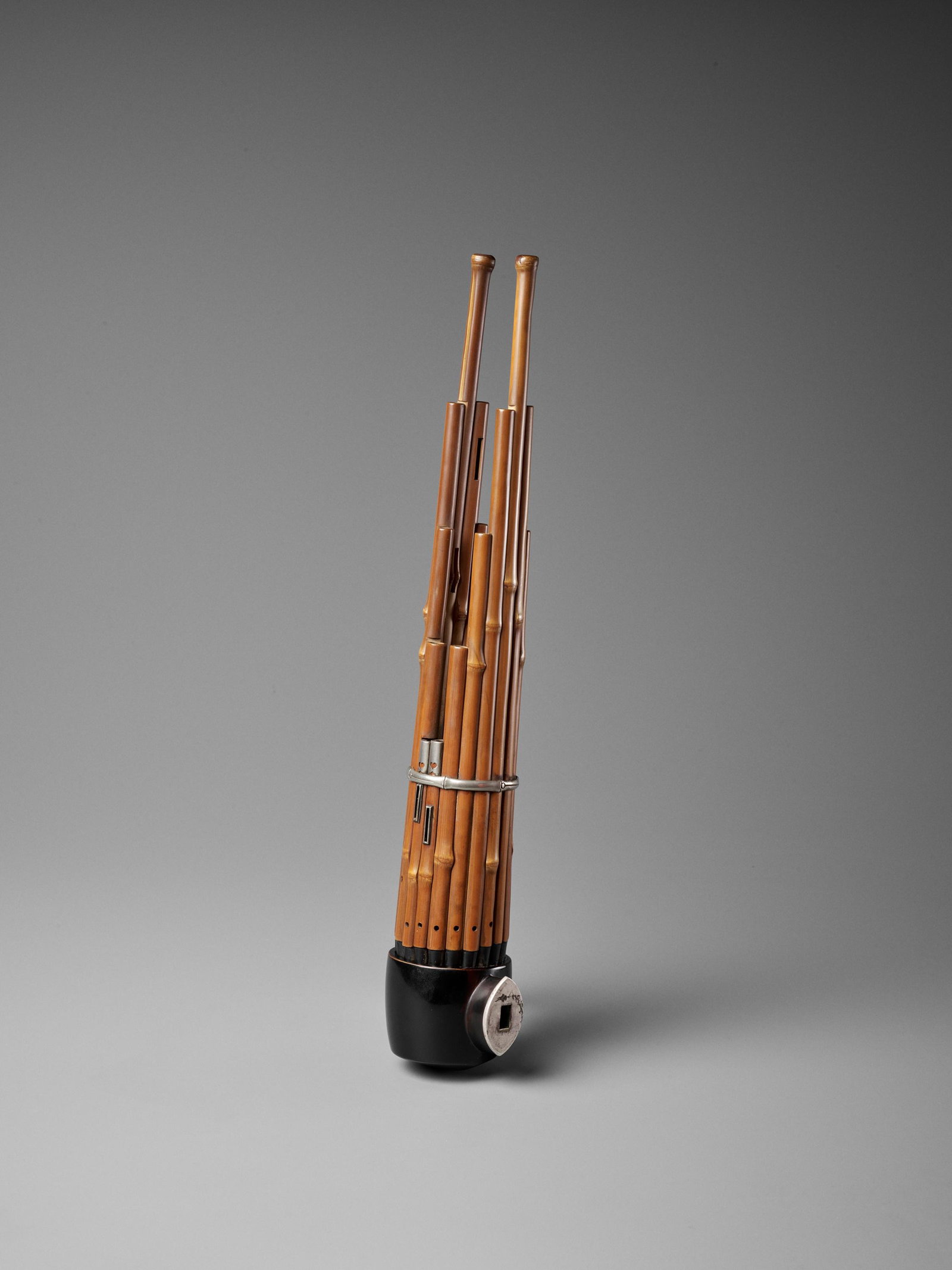 A BAMBOO AND LACQUER SHO (MOUTH ORGAN): A BAMBOO AND LACQUER SHO (MOUTH ORGAN) Japan, Meiji (1868-1912) to Taisho period (1912-1926) The bamboo pipes set into the black-lacquered base with silver mouthpiece and held with silver fittings. LE