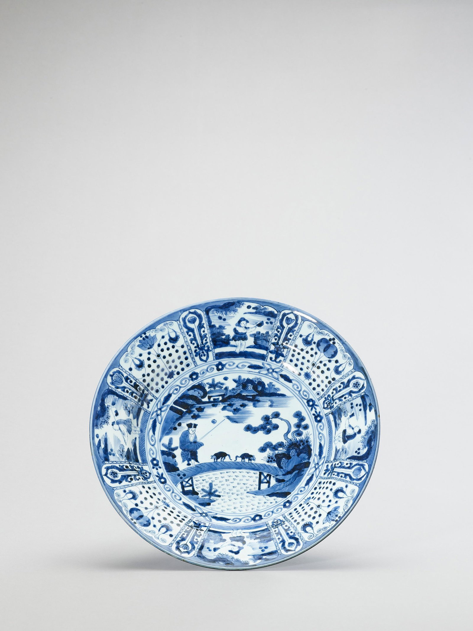 A LARGE BLUE AND WHITE PORCELAIN CHARGER: A LARGE BLUE AND WHITE PORCELAIN CHARGER Japan, Edo period (1615-1868) Painted in underglaze blue, the show side with a central drawing depicting a Dutch rat catcher with two rats on a bridge, surroun