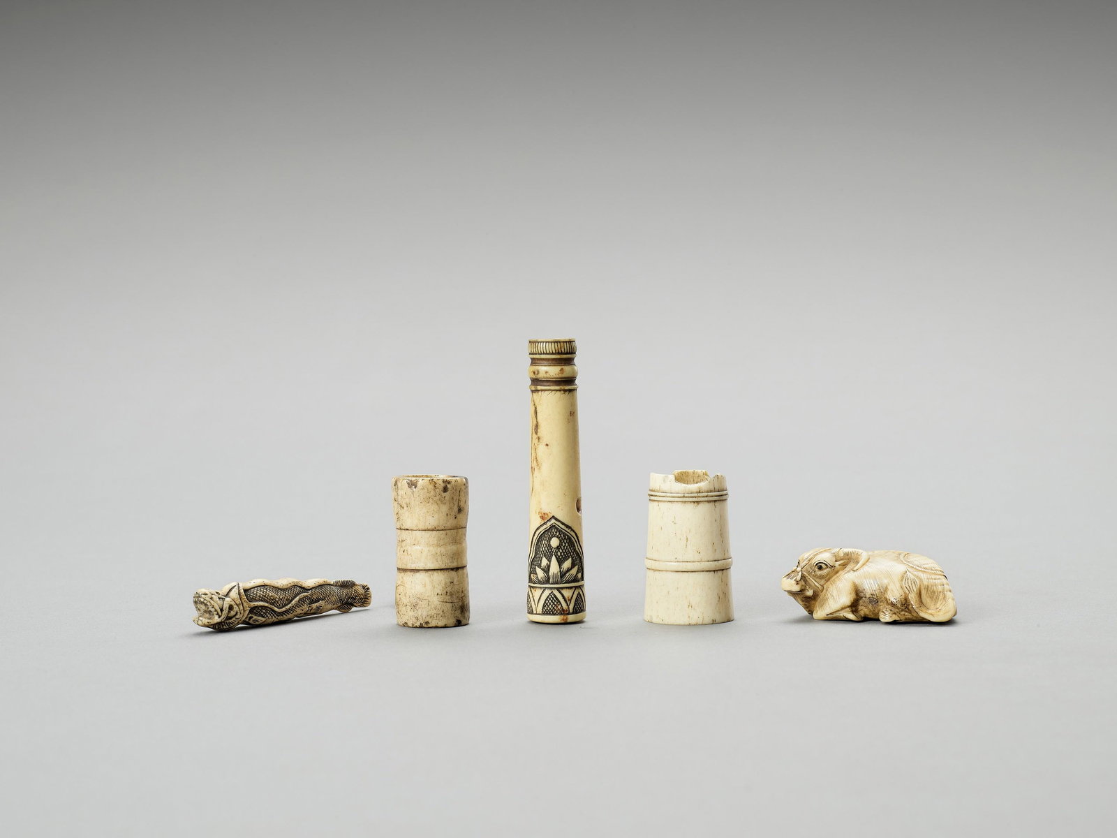 FOUR STAG ANTLER AND ONE BONE NETSUKE: FOUR STAG ANTLER AND ONE BONE NETSUKE Two signed, the others unsigned Japan, 19th century to Meiji period (1868-1912) Two stag antler netsuke of water buckets, one stag antler netsuke of a moray eel, 
