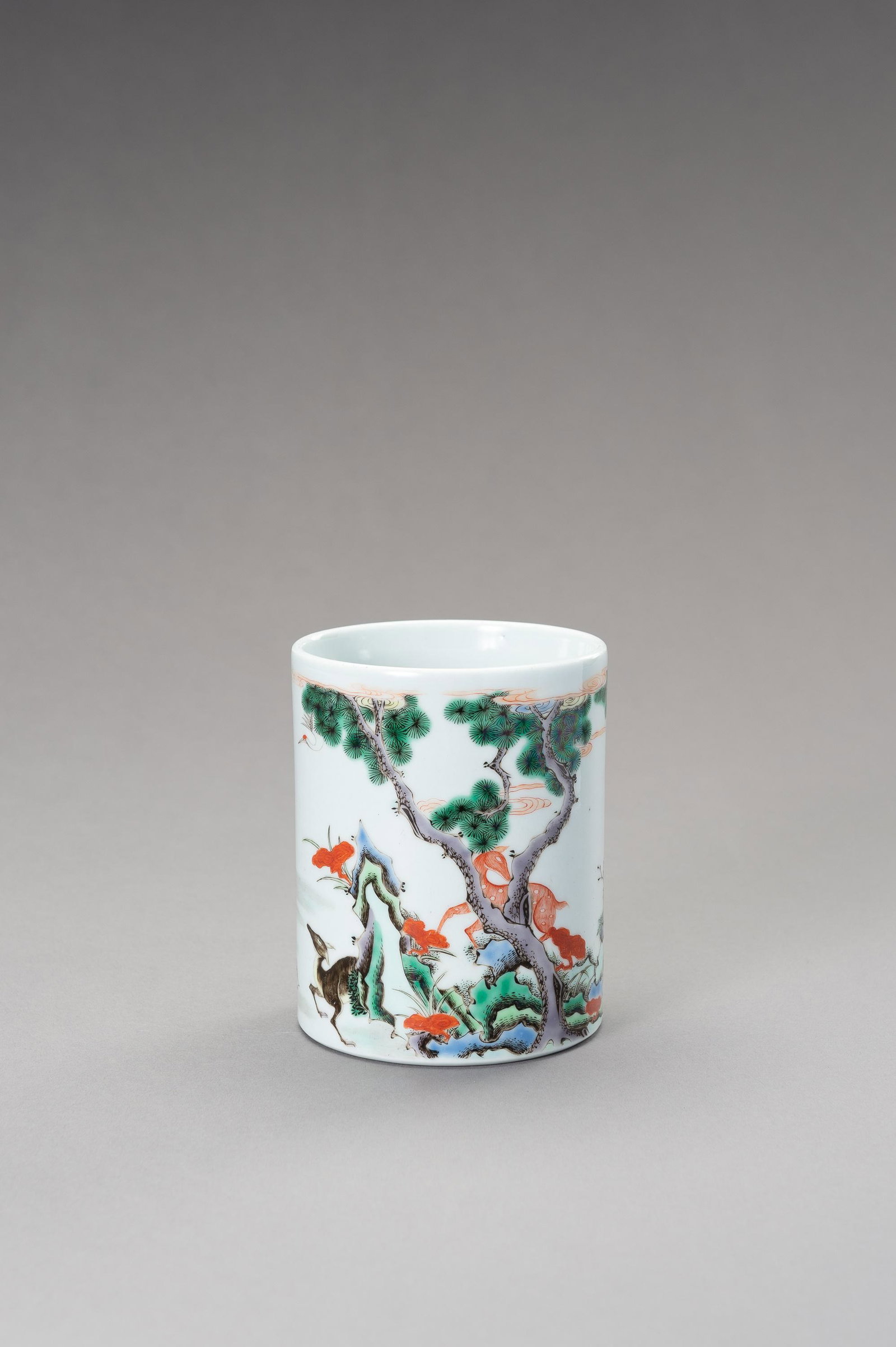 A 'DEERS AND CRANES' BRUSHPOT, QING TO REPUBLIC: A FAMILLE VERTE 'DEERS AND CRANES' BRUSHPOT, BITONG, LATE QING TO REPUBLIC China, late Qing dynasty (1644-1912) to Republic period (1912-1949). Of cylindrical form rising from a flat partially unglaze