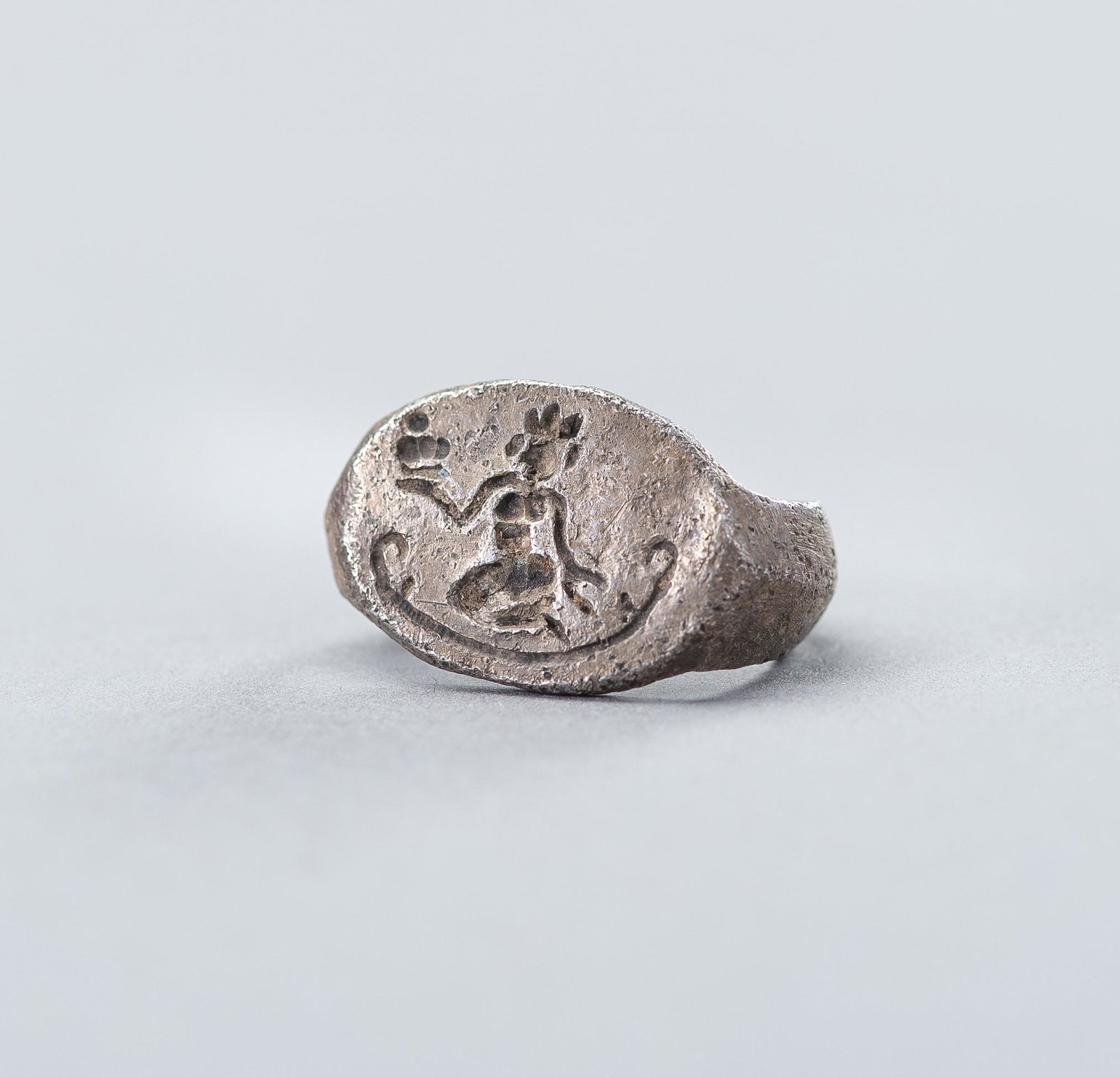 A PYU SILVER ALLOY 'LAKSHMI' RING, 9-11TH CT: A PYU CULTURE SILVER ALLOY 'LAKSHMI' RING, 9TH TO 11TH CENTURY Burma/Myanmar region, Pyu city states, circa 9th - 11th century. The ring of simplistic shape, with broad shoulders, the bezel incised wi