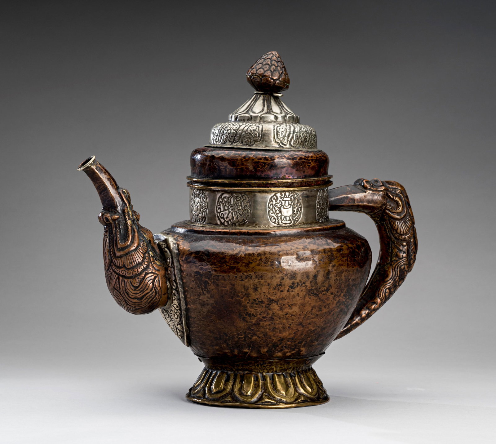 A TIBETAN COPPER EWER, 19th CENTURY: A TIBETAN COPPER EWER, 19th CENTURY Tibet, late 19th century. Crafted in copper and set with a dragon handle and a curved spout issuing from the mouth of a further dragon, the neck and base with white