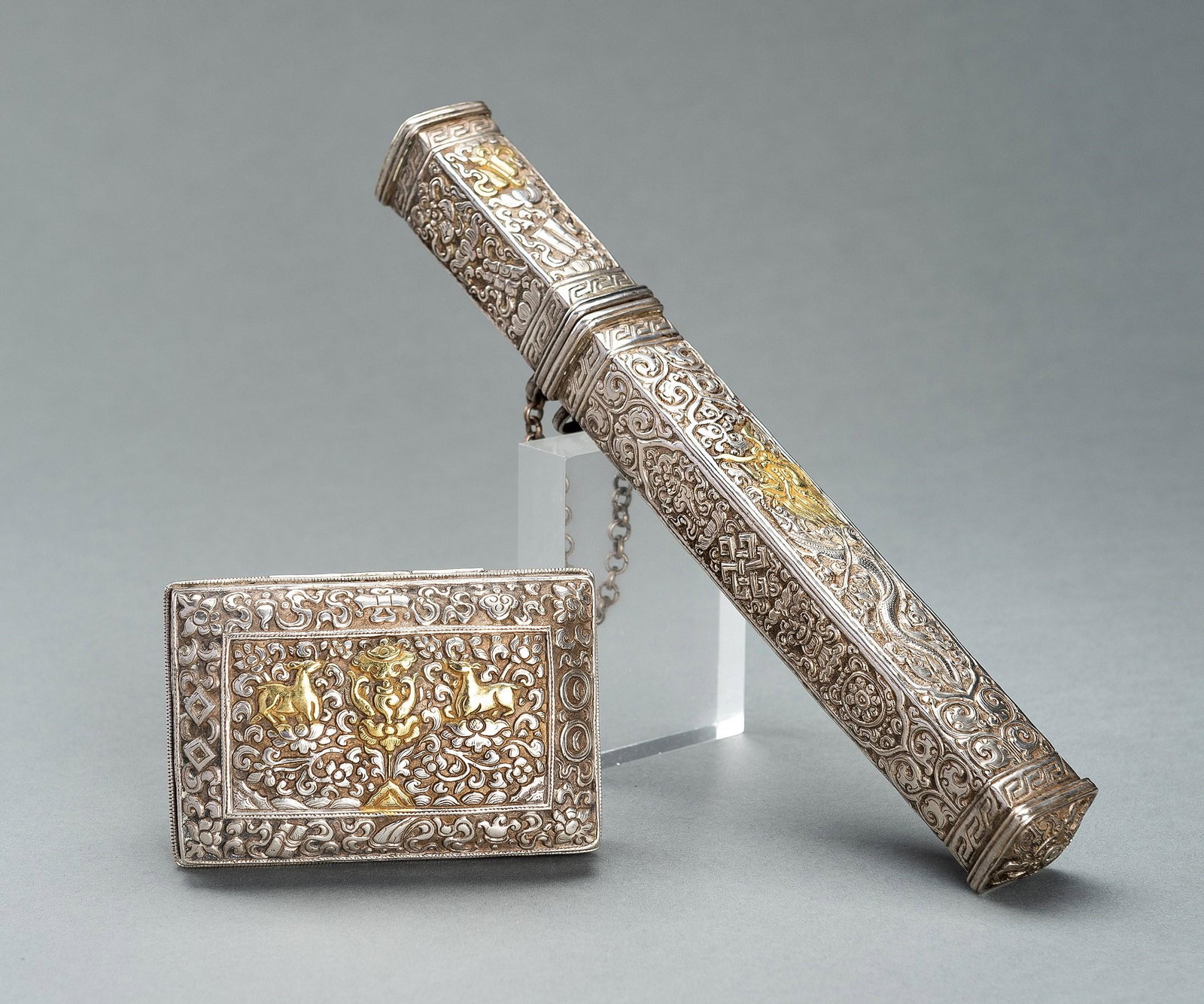 TWO EMBOSSED SILVERPLATED AND GILT METAL BOXES, 19TH CENTURY: TWO EMBOSSED SILVERPLATED AND GILT METAL BOXES, 19TH CENTURY Tibet, late 19th century. Comprising a rectangular box embossed and incised with floral designs to one side and edges and with auspicious s