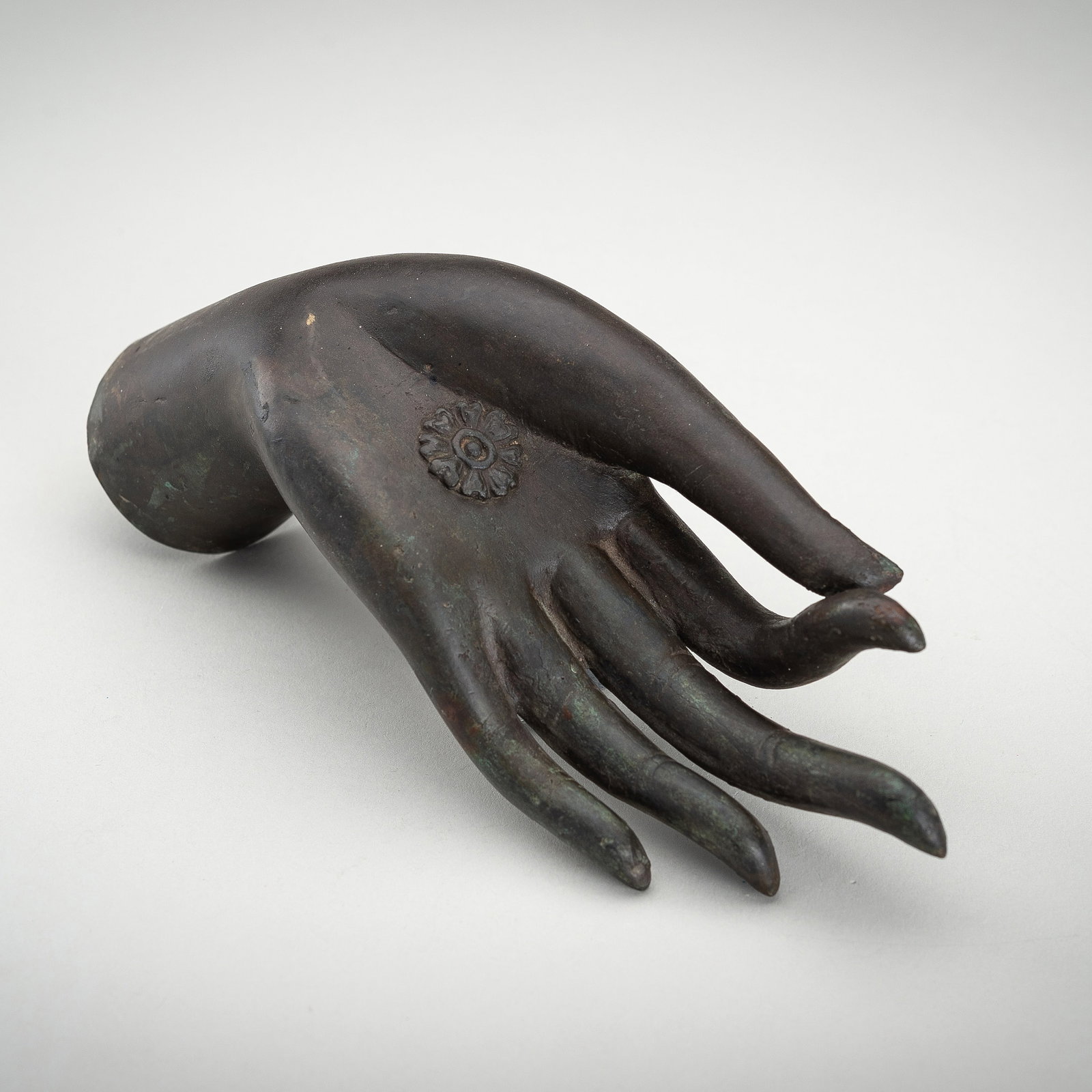 A BRONZE HAND OF BUDDHA, 1900s: A BRONZE HAND OF BUDDHA, 1900s Thailand, late 19th – early 20th century. Cast with thin and elongated fingers in the vitarka mudra gesture, which represents "the gesture of debate" - explaining 