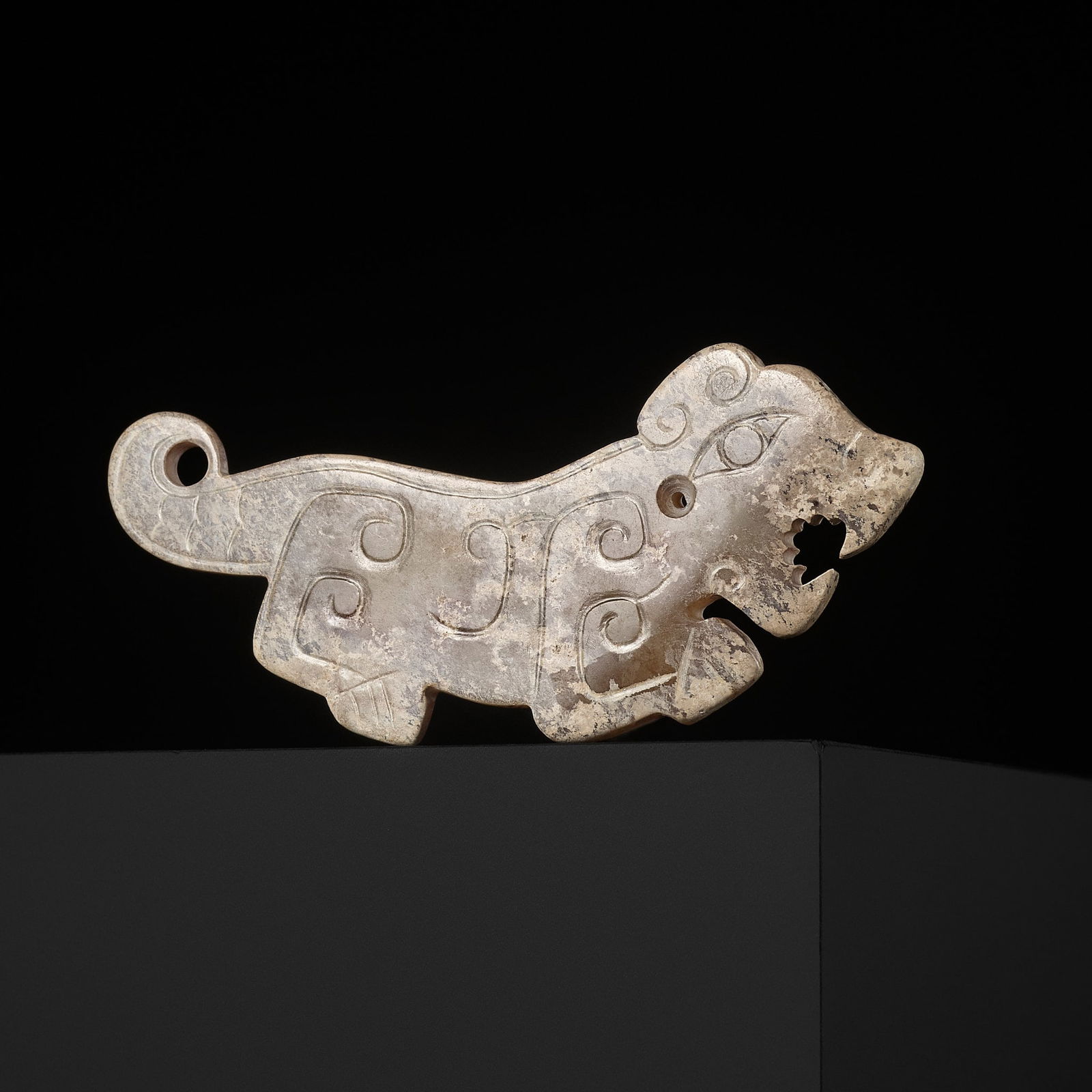 A PALE CELADON JADE 'TIGER' PENDANT, WESTERN ZHOU DYNASTY (1 of 10)