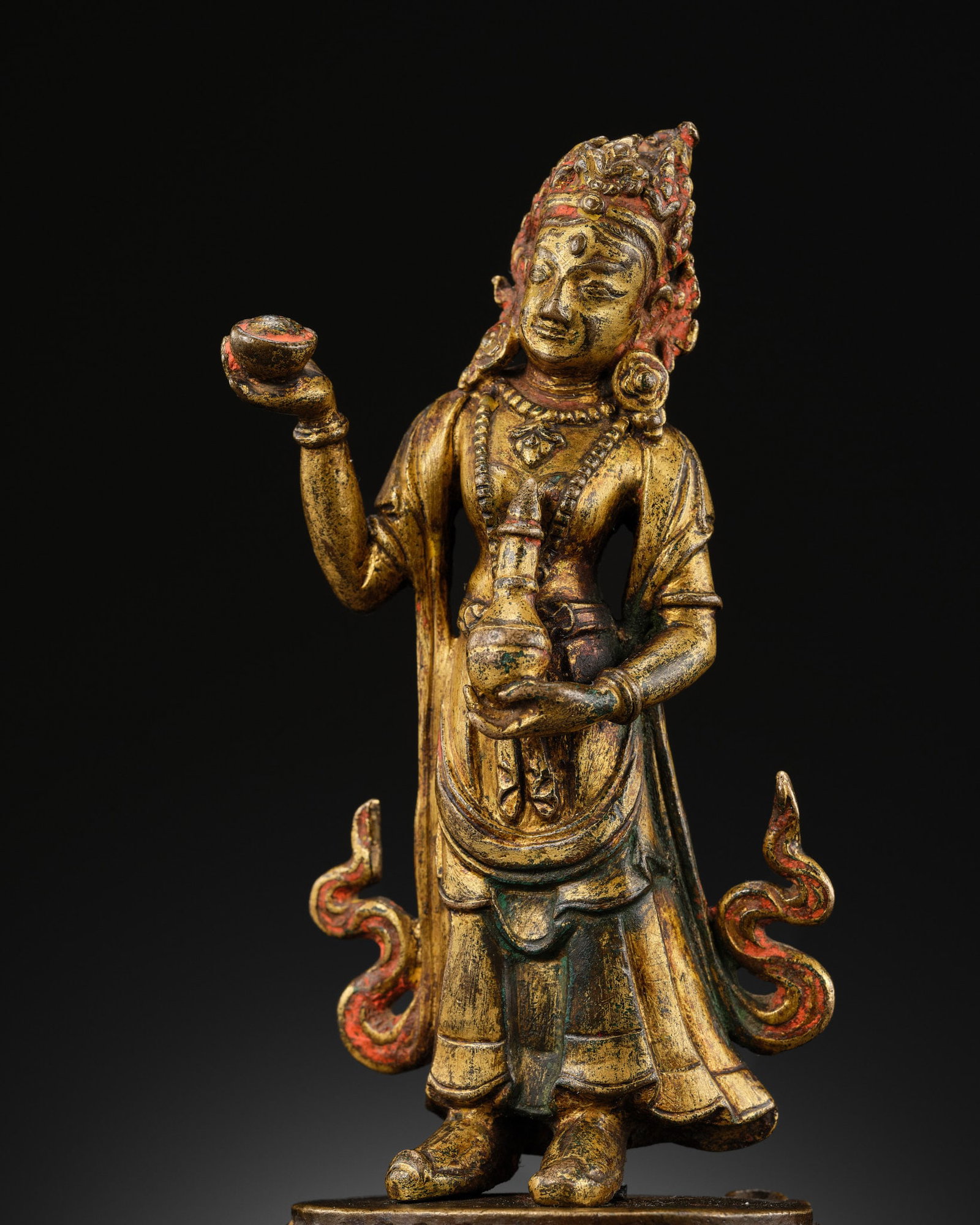 A RARE GILT-BRONZE FIGURE OF NAIRATMYA, NEPAL, MALLA PERIOD, 14TH-15TH CENTURY: A RARE GILT-BRONZE FIGURE OF NAIRATMYA, NEPAL, MALLA PERIOD, 14TH-15TH CENTURY Finely cast, standing with hips elegantly swayed in tribhanga on a double lotus base, raising a kapala in her left hand a