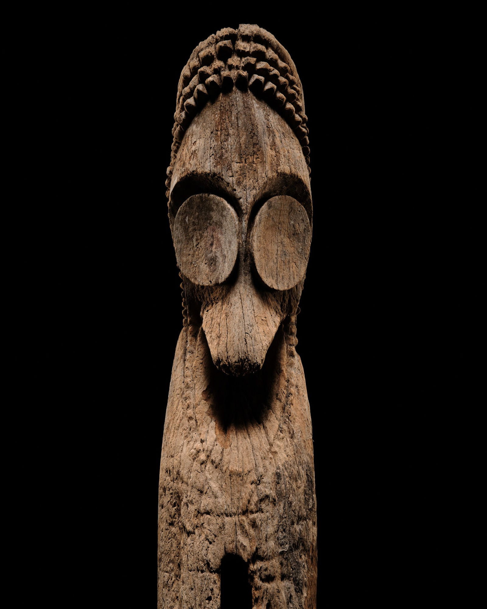 A LARGE AND IMPRESSIVE HARDWOOD SLIT GONG, ATINGTING KON: A LARGE AND IMPRESSIVE HARDWOOD SLIT GONG, ATINGTING KON Vanuatu, Ambrym Island, late 19th-early 20th century. Carved from a large section of breadfruit tree, the drum depicts an ancestral figure, fea