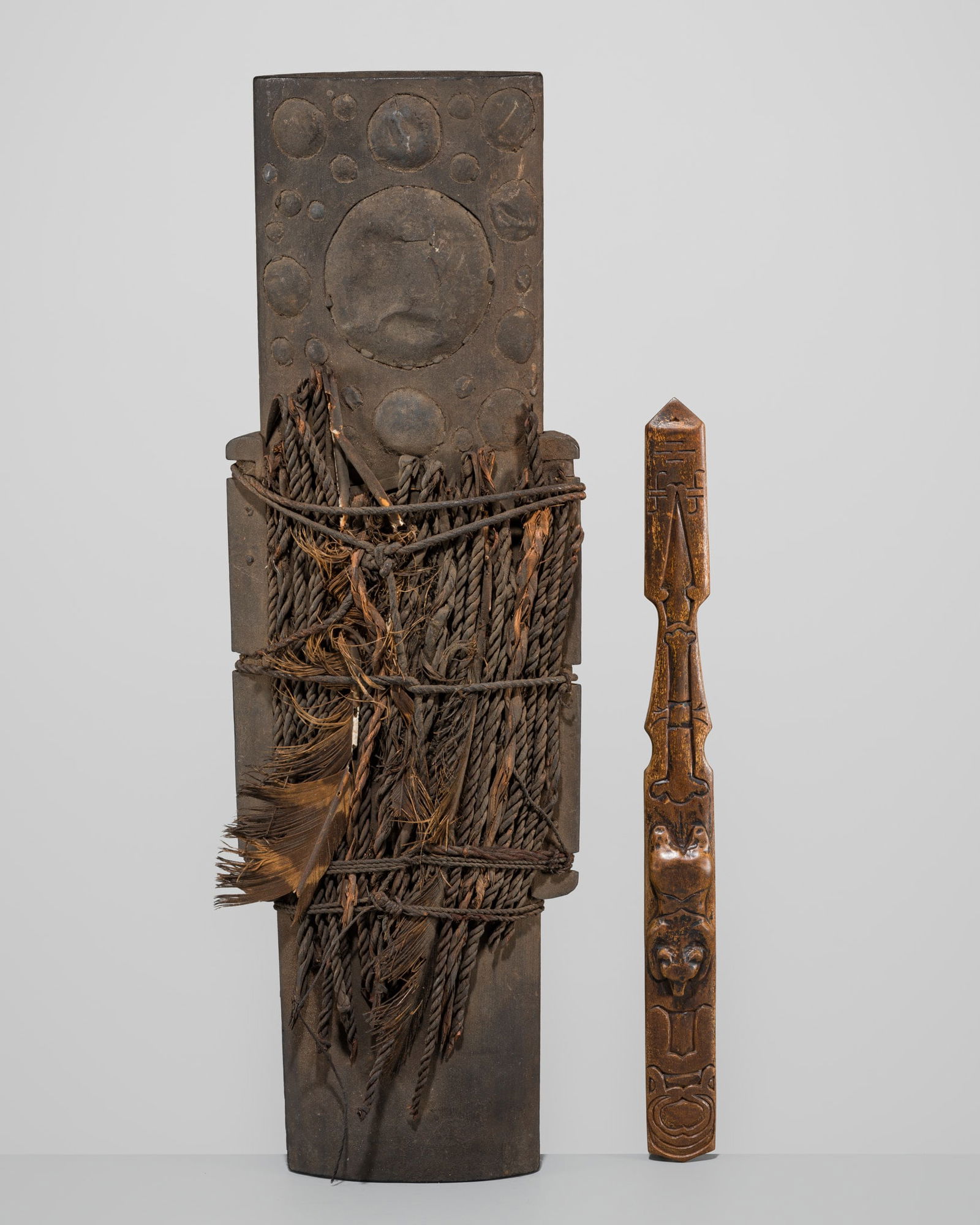 A GROUP OF TWO AINU OBJECTS: A GROUP OF TWO AINU OBJECTS Japan, mid-19th century, Edo period (1615-1868)The first carving is a slender wood ikupasuy (prayer stick) carved in the form of an arrow, the body finely carved in relief