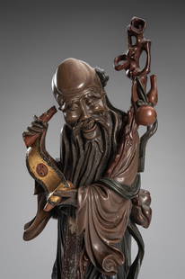 A FUZHOU LACQUERED WOOD FIGURE OF SHOULAO, REPUBLIC PERIOD: A FUZHOU LACQUERED WOOD FIGURE OF SHOULAO, REPUBLIC PERIOD China, 1912-1949. Finely carved to depict Shoulao, the Daoist deity of longevity, standing atop a lobed gilt metal base decorated with lappet