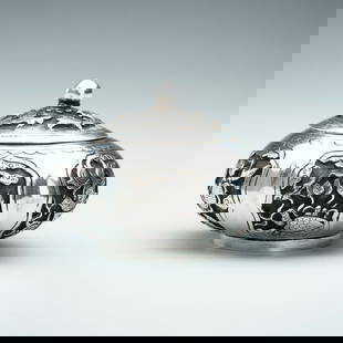A LIDDED SILVER MINIATURE BOX: A LIDDED SILVER MINIATURE BOX South China / Vietnam, 1880s &#8211; 1920s. The compressed lobed body supported on a short circular foot, finely embossed, and incised with various mythical creatures and