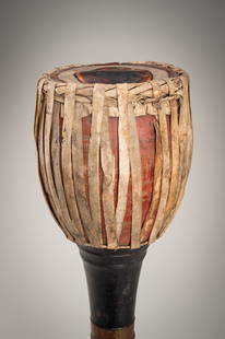 A BURMESE LACQUERED WOOD 'OZI' DRUM, LATE 19TH CENTURY: A BURMESE LACQUERED WOOD 'OZI' DRUM, LATE 19TH CENTURY Burma, Mandalay period. Supported on a long waisted foot flaring towards the base, lacquered at the center with bands of red and gilt, the goblet