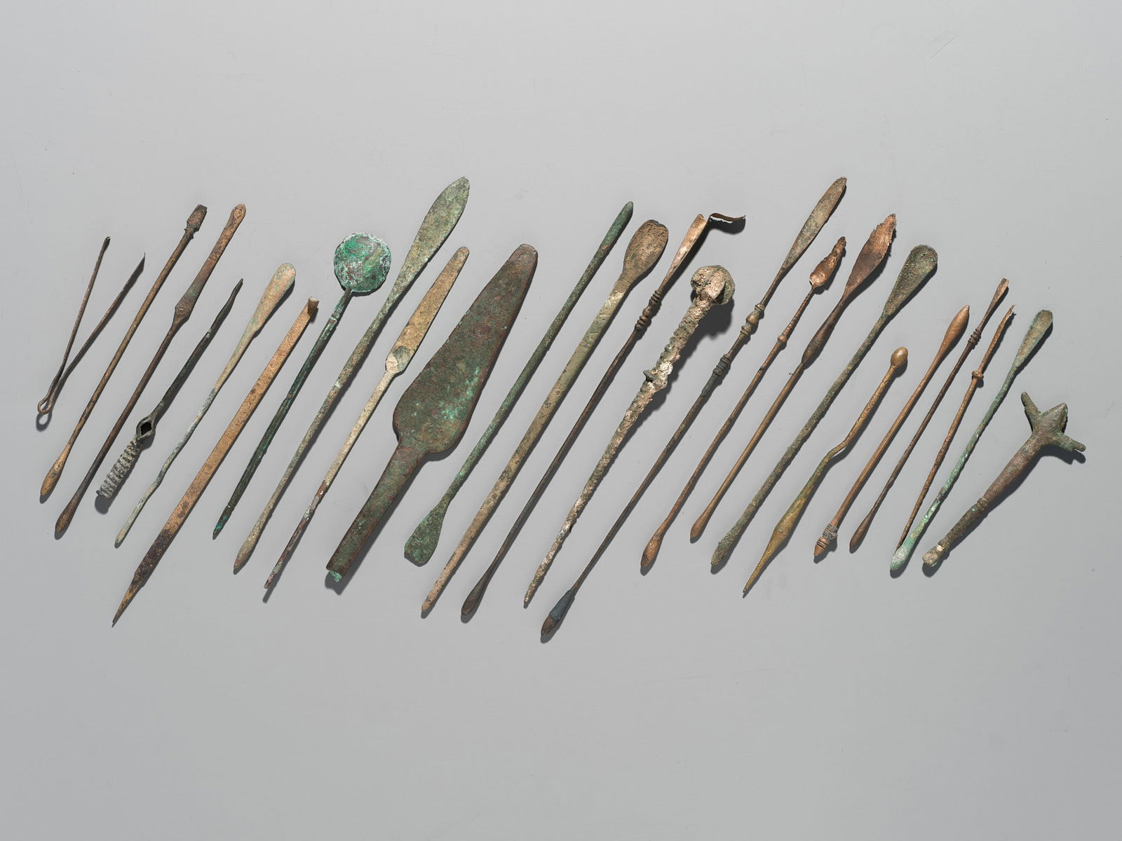 A GROUP OF TWENTY-FOUR GREEK AND ROMAN BRONZE PINS, SPOONS AND TOOLS, 1ST MILLENNIUM AD AND EARLIER (1 of 10)