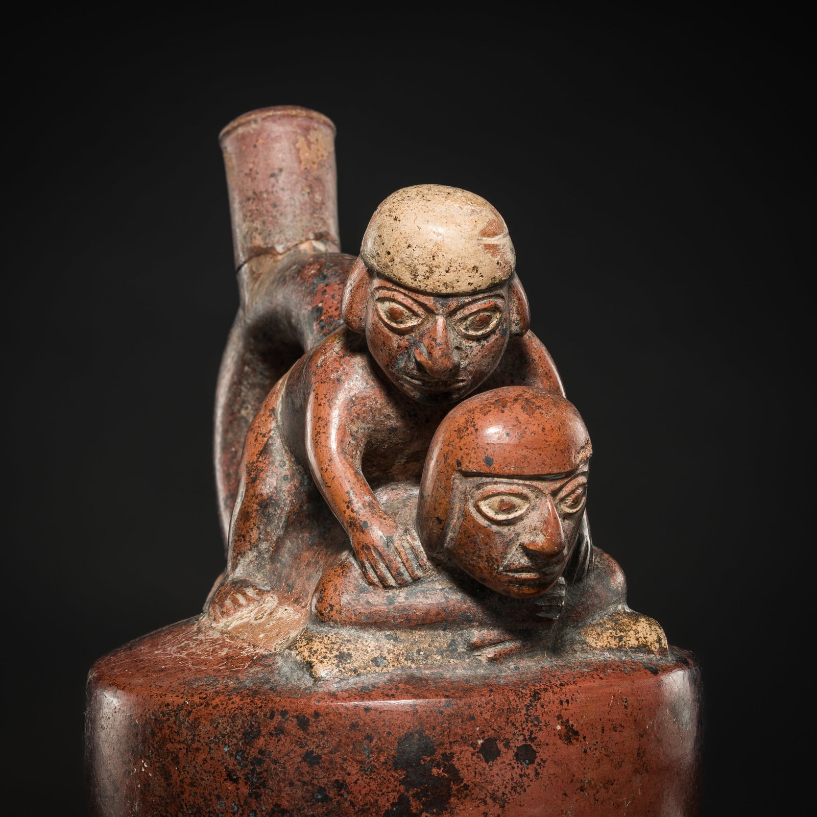 A CERAMIC STIRRUP-SPOUT VESSEL WITH AN EROTIC SCENE, MOCHE CULTURE: A CERAMIC STIRRUP-SPOUT VESSEL WITH AN EROTIC SCENE, MOCHE CULTURE Peru, Moche civilization, (c. 100-800 AD). The compressed vessel rising from a slightly convex foot and decorated to the shoulder wit