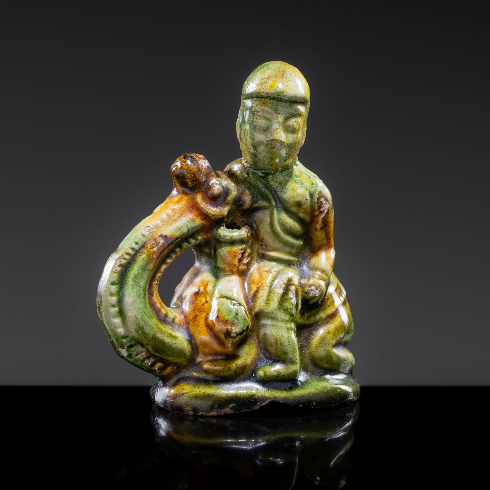 A SANCAI-GLAZED POTTERY FIGURE OF A CAMEL RIDER, TANG DYNASTY (1 of 14)