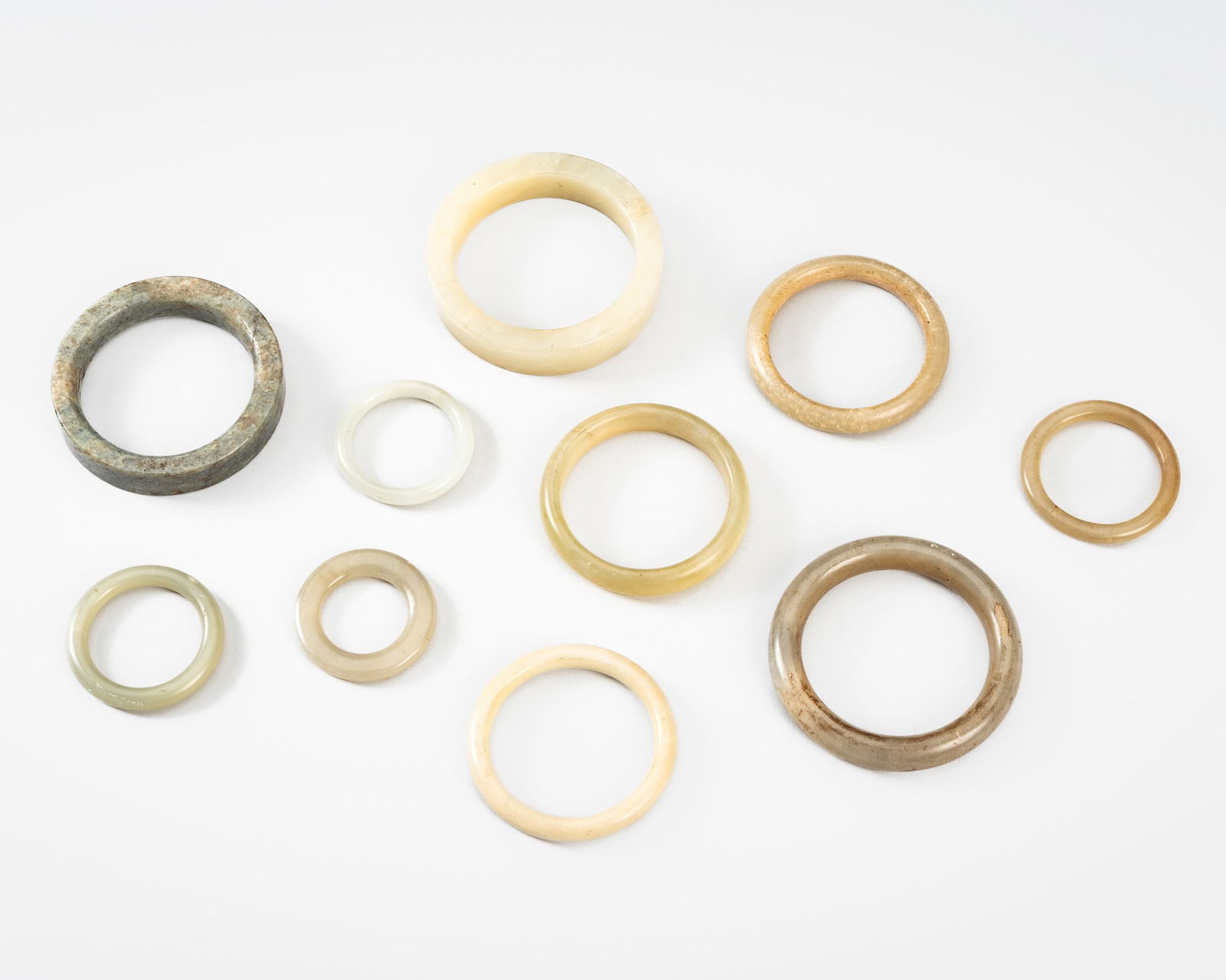 A GROUP OF TEN JADE AND JADEITE BANGLES, 1900s: A GROUP OF TEN JADE AND JADEITE BANGLES, 1900s China, late Qing dynasty (1644-1912) to Republic period (1912-1949). Comprising three smaller jade bangles, a pale gray jadeite bangle with a tiny apple-