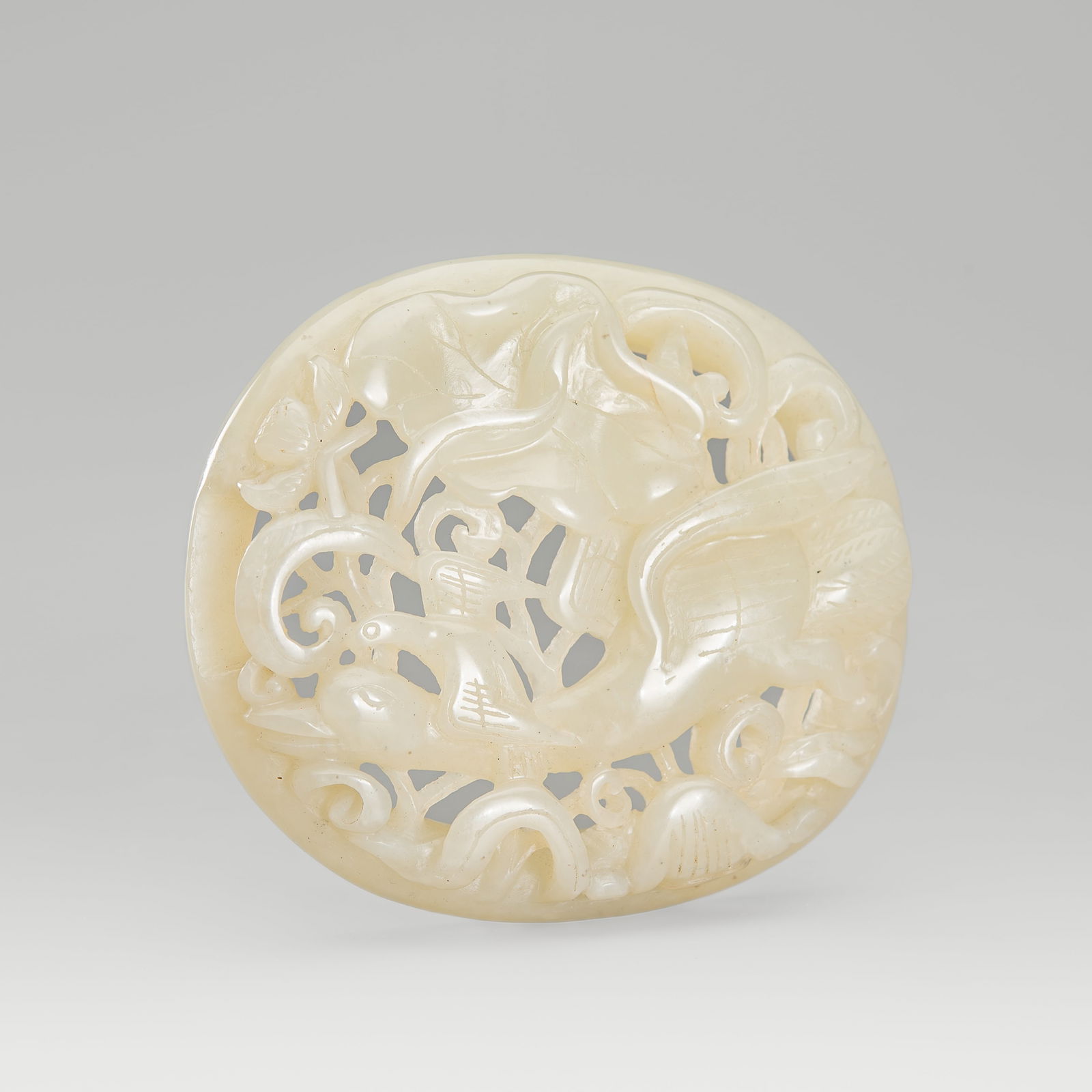 A PALE CELADON JADE OPENWORK 'SPRING WATER' PLAQUE, c. 1900s: A PALE CELADON JADE OPENWORK 'SPRING WATER' PLAQUE, c. 1900s China, late Qing Dynasty (1644-1912) to Republic period (1912-1949). Of oval form, intricately carved in openwork and in layered relief to
