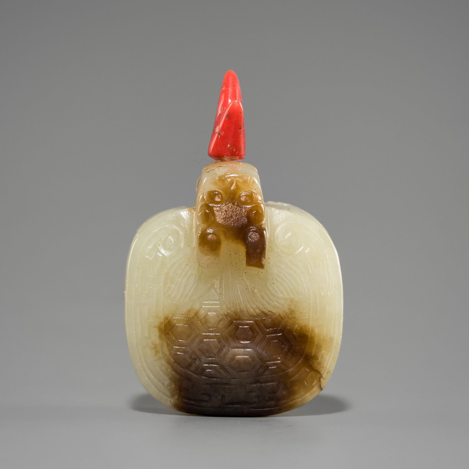 A RARE PALE CELADON AND BROWN JADE SNUFF BOTTLE IN THE FORM OF A TORTOISE, LATE QING DYNASTY: A RARE PALE CELADON AND BROWN JADE SNUFF BOTTLE IN THE FORM OF A TORTOISE, LATE QING DYNASTY China, 19th century or later. Finely hollowed, the caparison forming the body, of square form with rounded