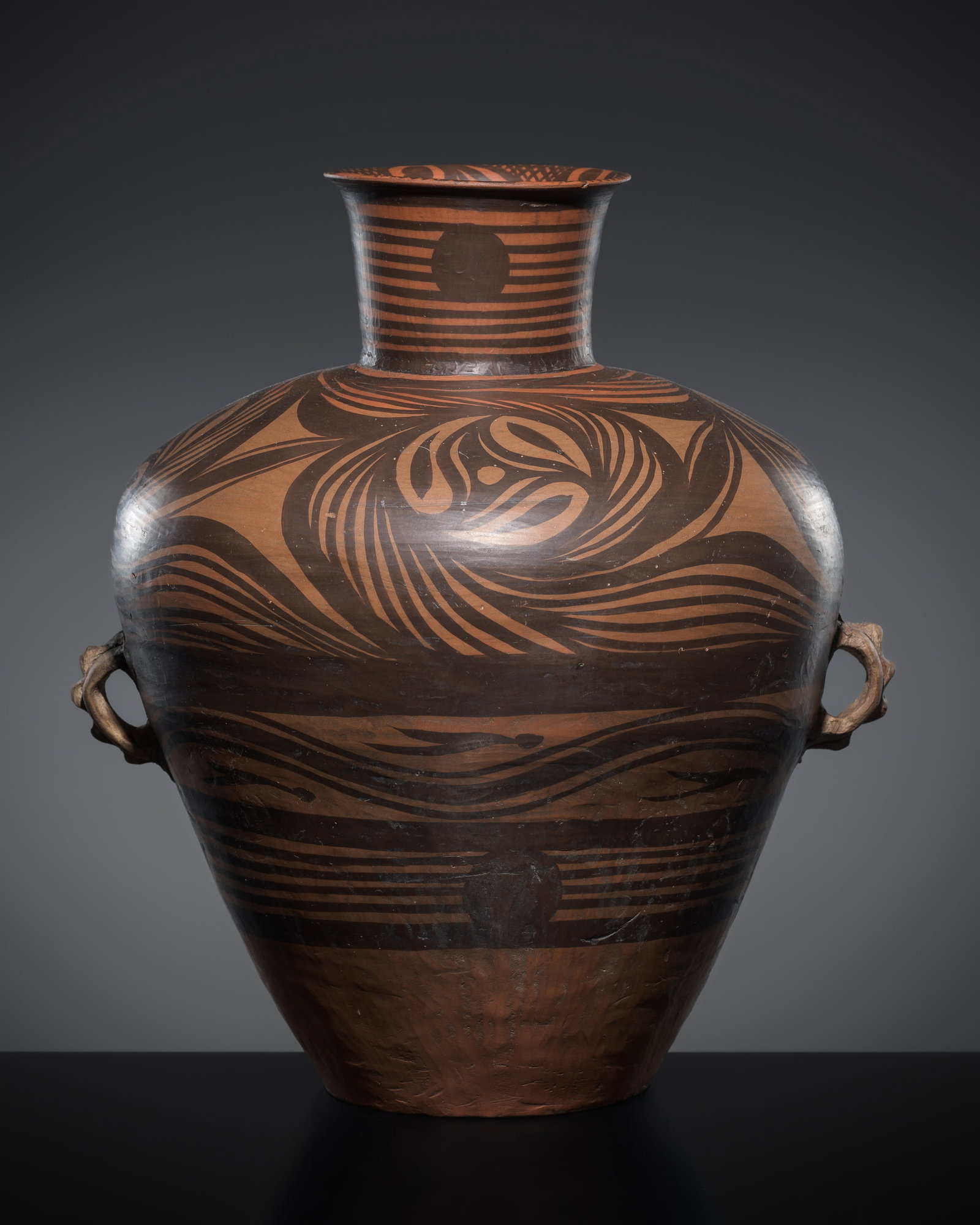 A PAINTED POTTERY AMPHORA VASE, MAJIAYAO STYLE: A PAINTED POTTERY AMPHORA VASE, MAJIAYAO STYLE Expert's note: Expressive polychrome designs on ancient archaic wares from China, such as those on the present lot, are said to have inspired the Art Dec