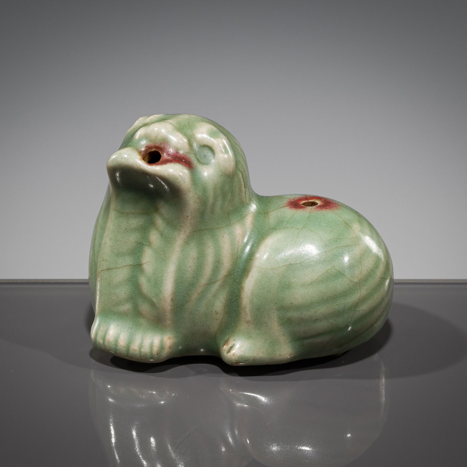 A 'BUDDHIST LION' WATER DROPPER, GORYEO DYNASTY: A 'BUDDHIST LION' WATER DROPPER, GORYEO DYNASTY Korea, 918-1392. The stylized Buddhist lion covered overall in a thick celadon glaze, nicely pooling in the recesses, with its head lifted, propping its