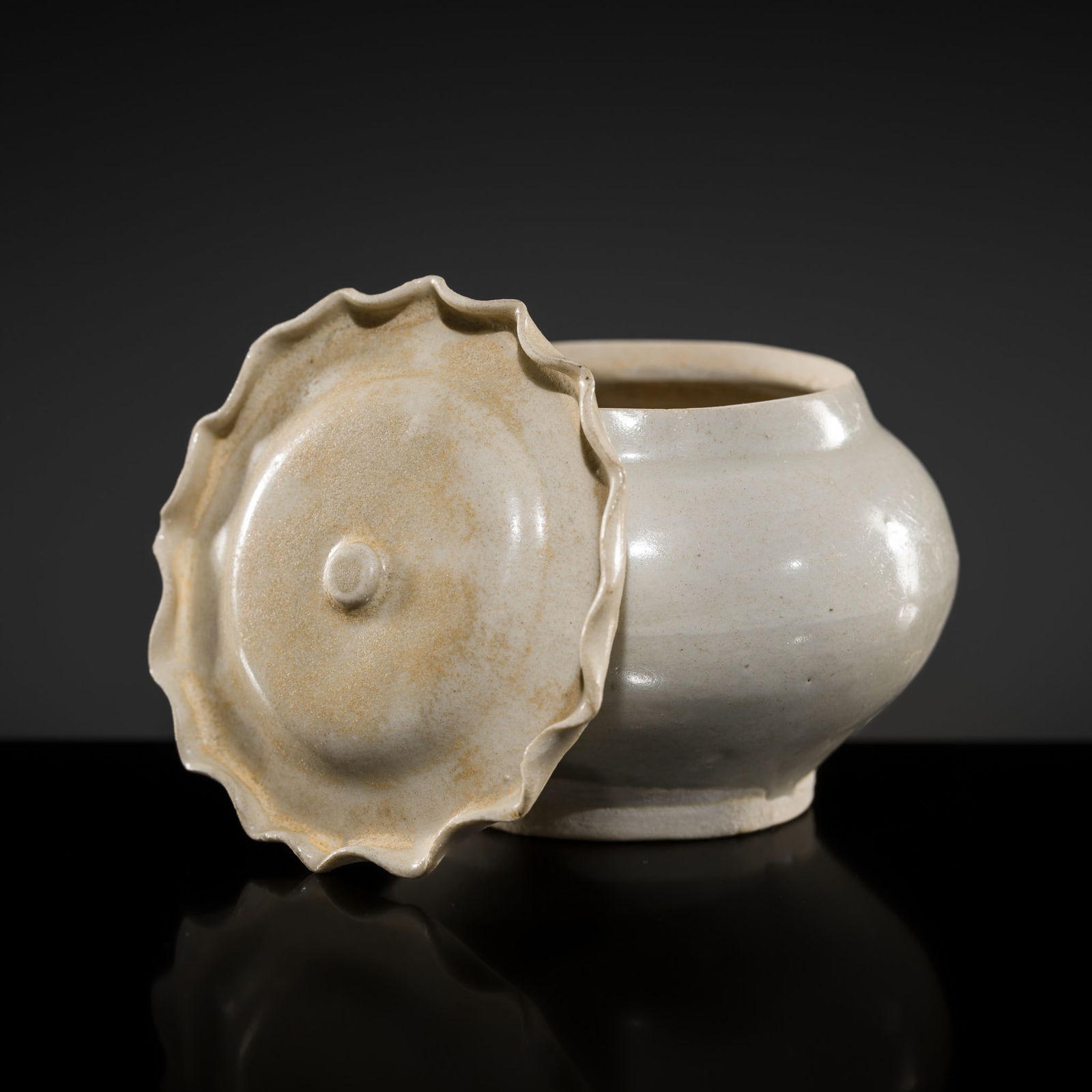 A RARE LONGQUAN PALE CELADON JAR AND COVER, SOUTHERN SONG DYNASTY: A RARE LONGQUAN PALE CELADON JAR AND COVER, SOUTHERN SONG DYNASTY China, 1127-1279. Delicately potted, of baluster form rising from a short convex base encircled by an unglazed foot. The lotus leaf-f
