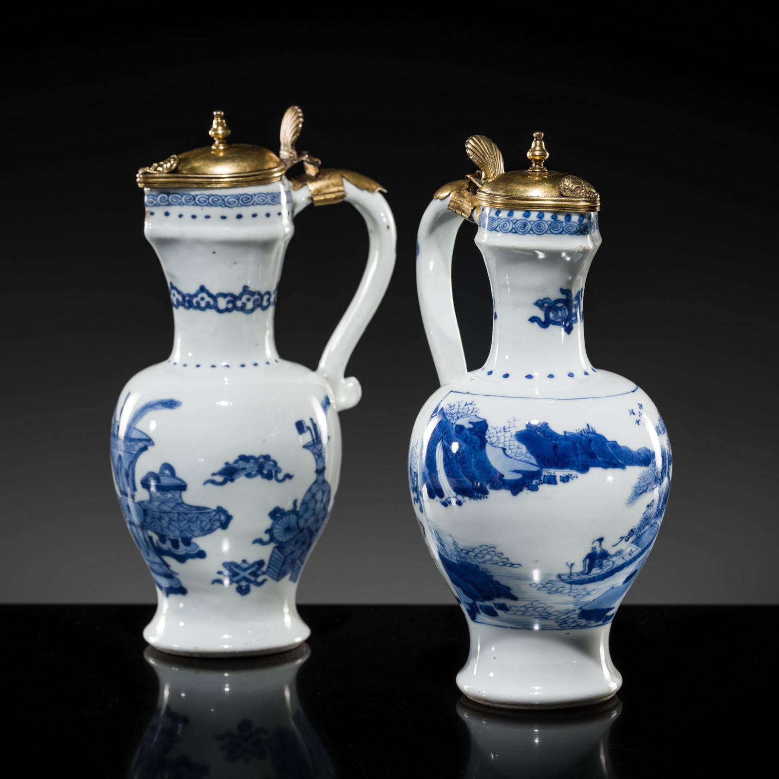 A PAIR OF GILT-BRONZE MOUNTED BLUE AND WHITE EWERS, TRANSITIONAL PERIOD: A PAIR OF GILT-BRONZE MOUNTED BLUE AND WHITE EWERS, TRANSITIONAL PERIOD China, 17th century (ewers); Northern Europe, 18th century (mounts). Each of baluster form, rising from a gently flaring foot t
