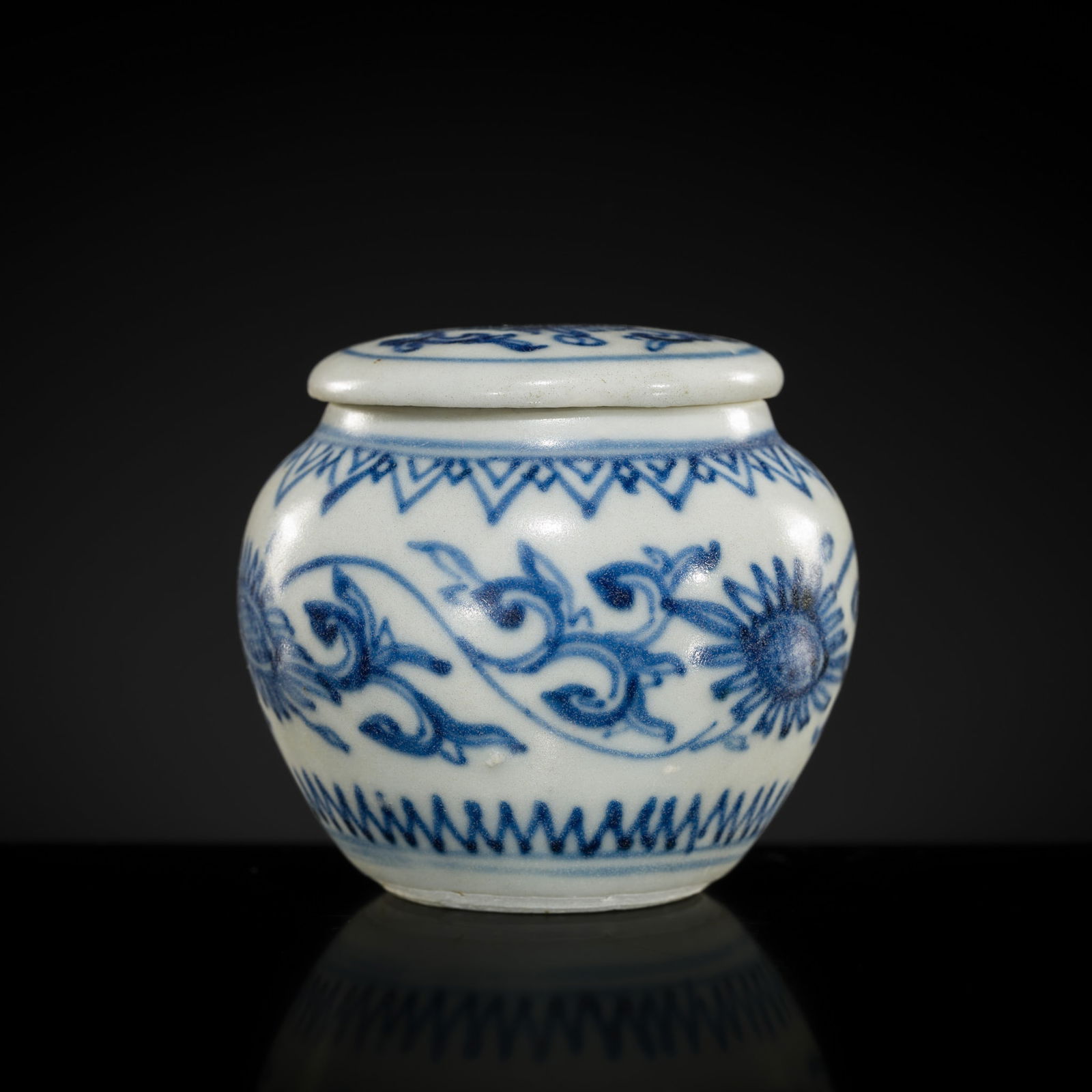 A MINIATURE BLUE AND WHITE 'CHRYSANTHEMUM' JAR AND COVER, TRANSITIONAL PERIOD, FROM THE HATCHER: A MINIATURE BLUE AND WHITE 'CHRYSANTHEMUM' JAR AND COVER, TRANSITIONAL PERIOD, FROM THE HATCHER CARGO China, c. 1643-1645. Finely potted with a swelling, high-shouldered body supported on a ring foot