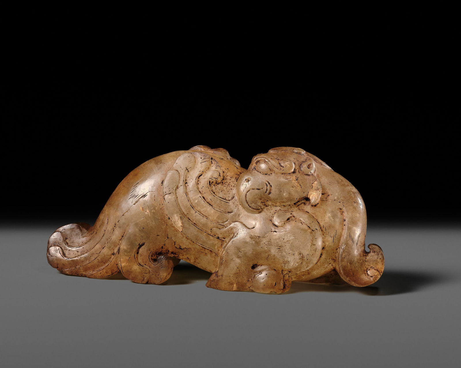 A LARGE ROCK CRYSTAL FIGURE OF A PHOENIX, HAN DYNASTY: A LARGE ROCK CRYSTAL FIGURE OF A PHOENIX, HAN DYNASTY China, 206 BC-220 AD. Boldly carved, the crouching beast standing on its two muscular feet, the body with long curled wings and tail feathers, it