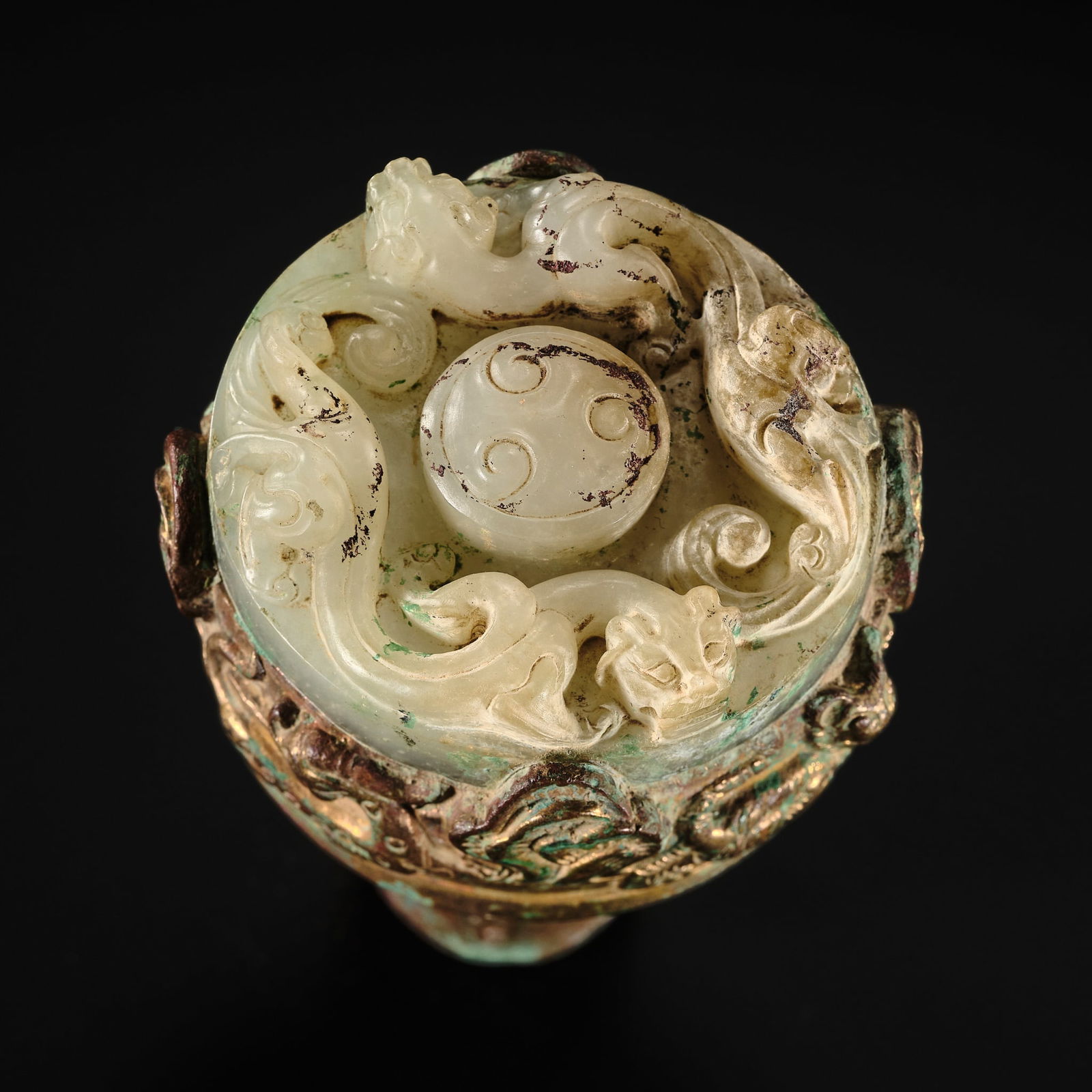 A VERY RARE JADE-INLAID GILT-BRONZE 'DRAGON' FINIAL, WESTERN HAN DYNASTY: A VERY RARE JADE-INLAID GILT-BRONZE 'DRAGON' FINIAL, WESTERN HAN DYNASTY China, c. 207 BC-9 AD. Finely cast, the head of the pommel cylindrical in form, supported on a slender hollow shaft, the sides