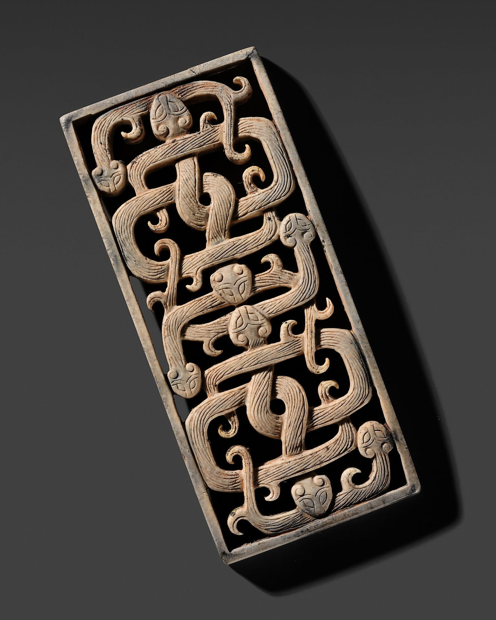 A MAGNIFICENT JADE 'SNAKE' VOTIVE PLAQUE, EASTERN ZHOU DYNASTY (1 of 12)