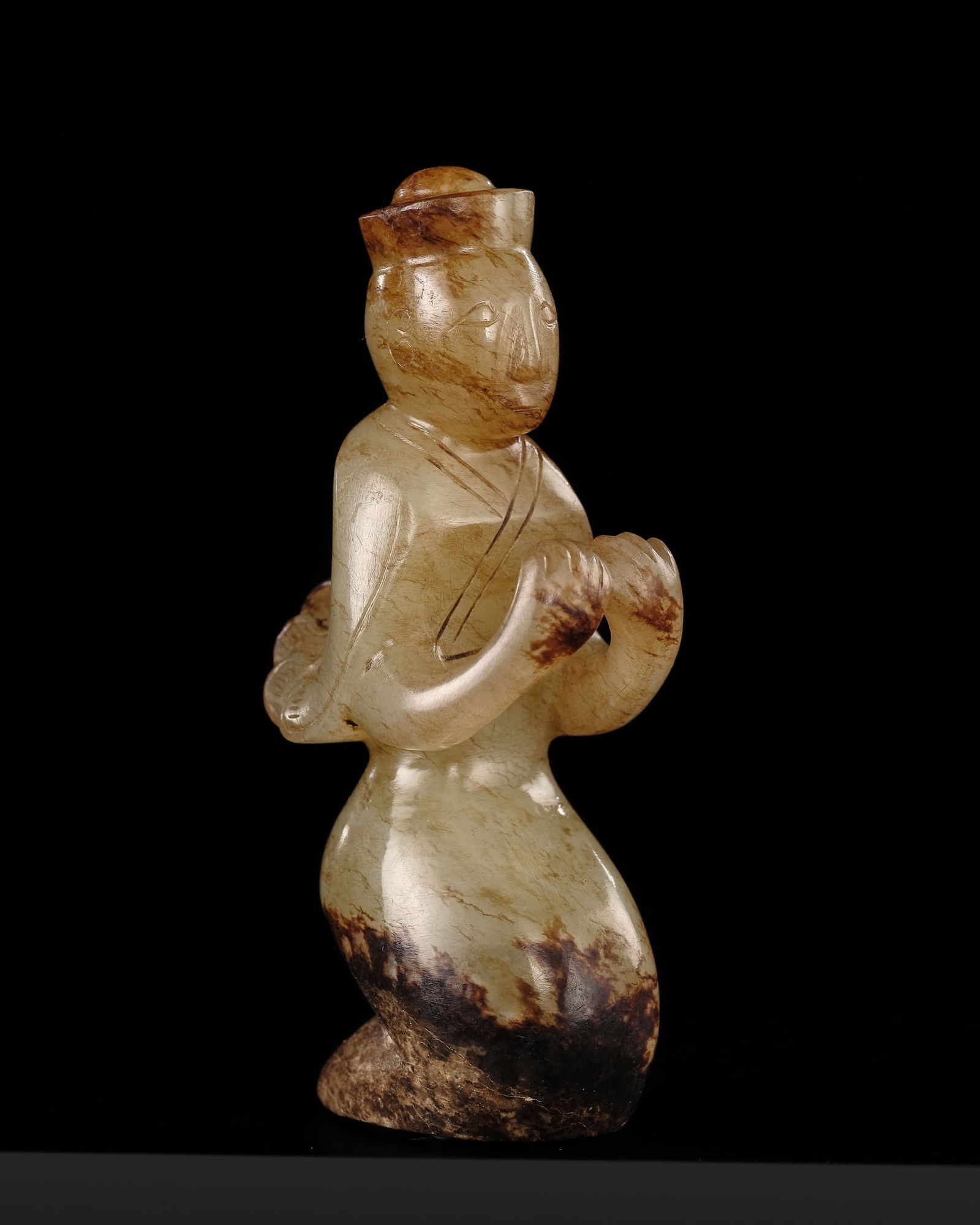 A RARE CELADON AND BROWN JADE WINGED IMMORTAL, HAN DYNASTY (1 of 19)