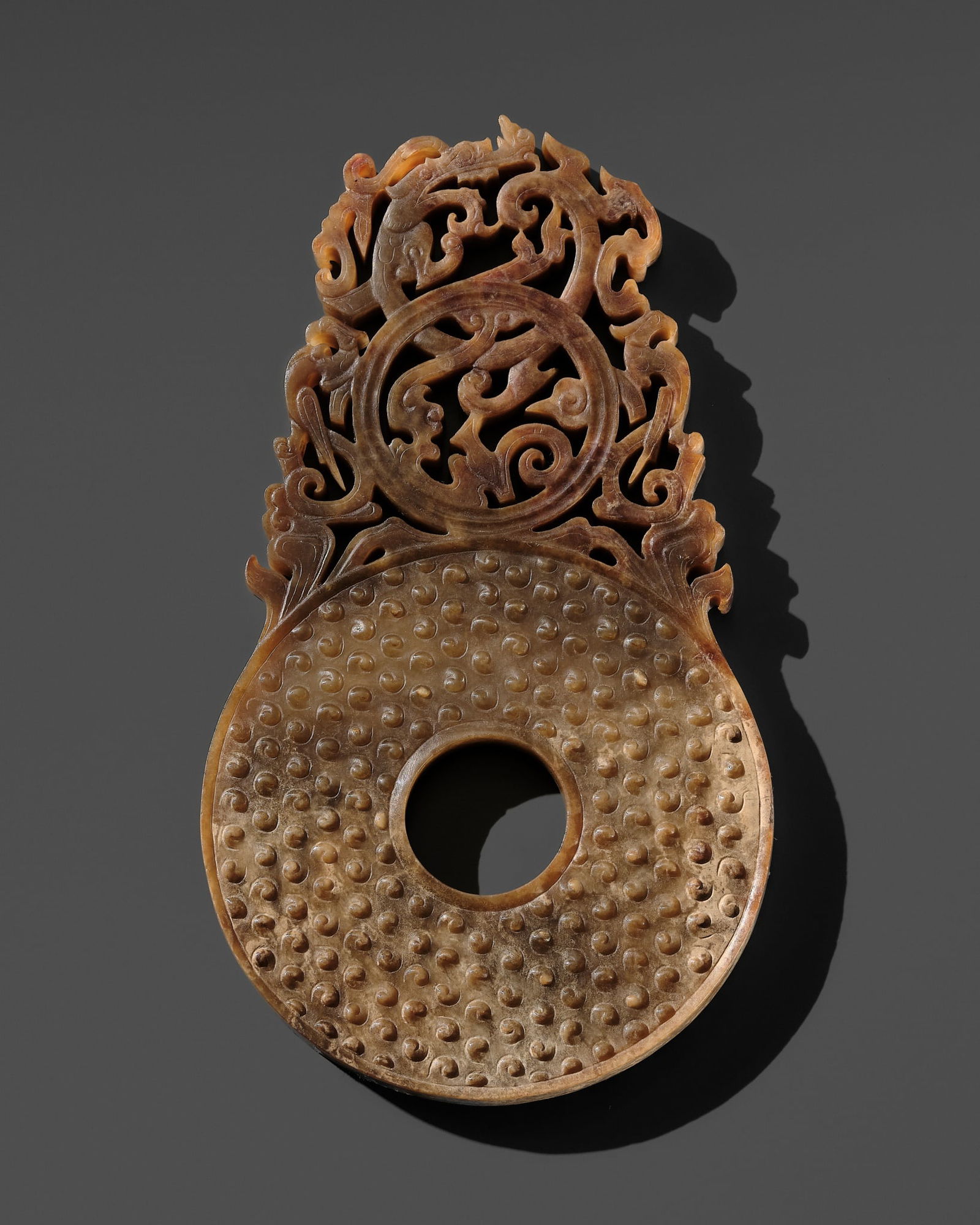 A BROWN AND CELADON JADE DISC WITH DRAGON AND PHOENIXES, BI, LATE WESTERN HAN DYNASTY (1 of 14)