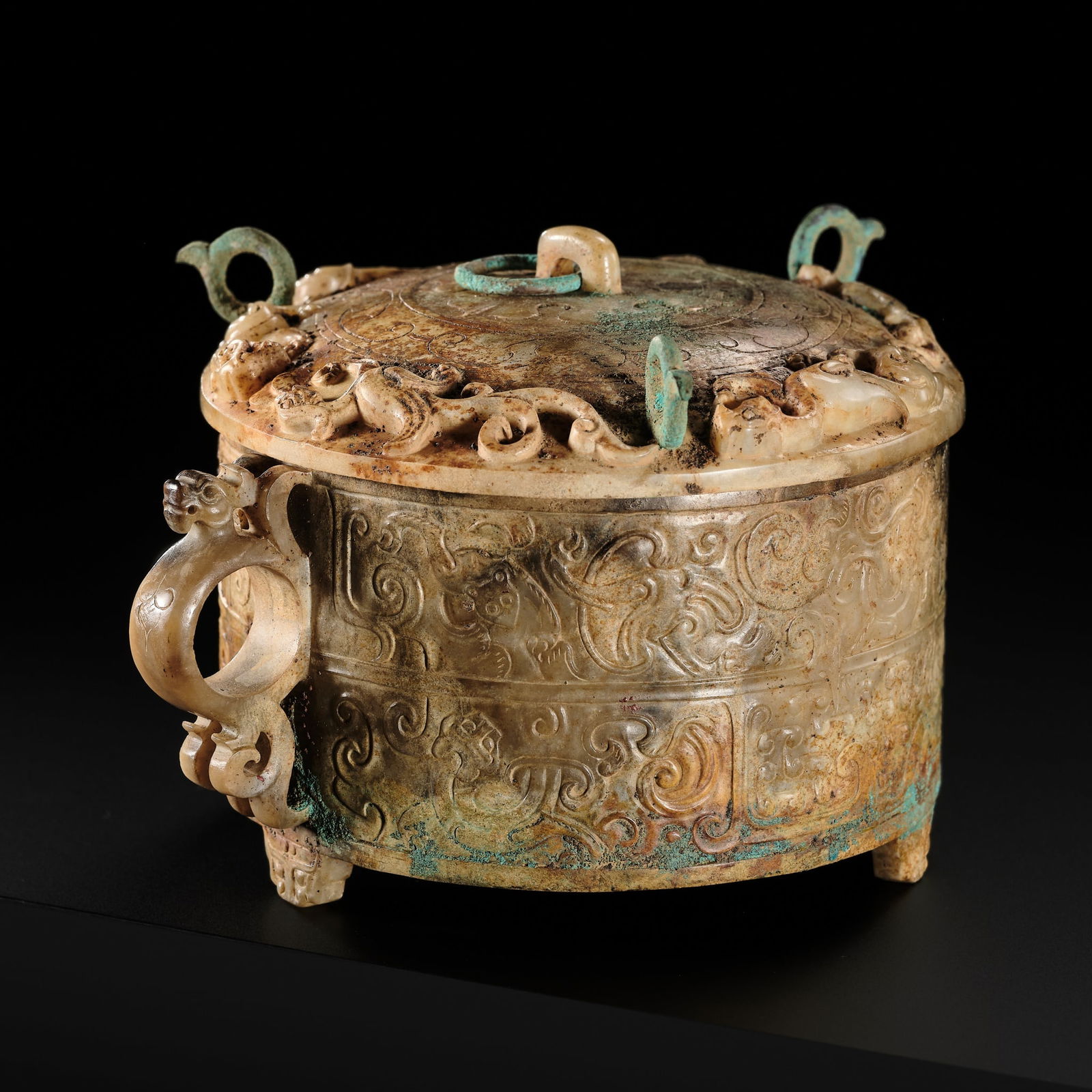 A JADE AND BRONZE 'AUSPICIOUS BEASTS' VESSEL AND COVER, ZHI, HAN DYNASTY: A JADE AND BRONZE 'AUSPICIOUS BEASTS' VESSEL AND COVER, ZHI, HAN DYNASTY China, 206 BC-220 AD. The cylindrical vessel is supported on three bracket feet in the form of taotie masks. The sides are dec
