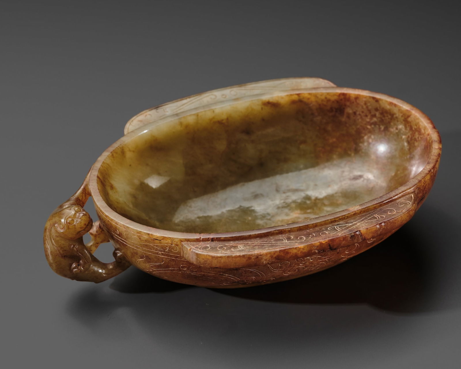 AN UNUSUAL CELADON AND RUSSET JADE EAR CUP WITH A BEAR-FORM HANDLE, HAN DYNASTY (1 of 20)