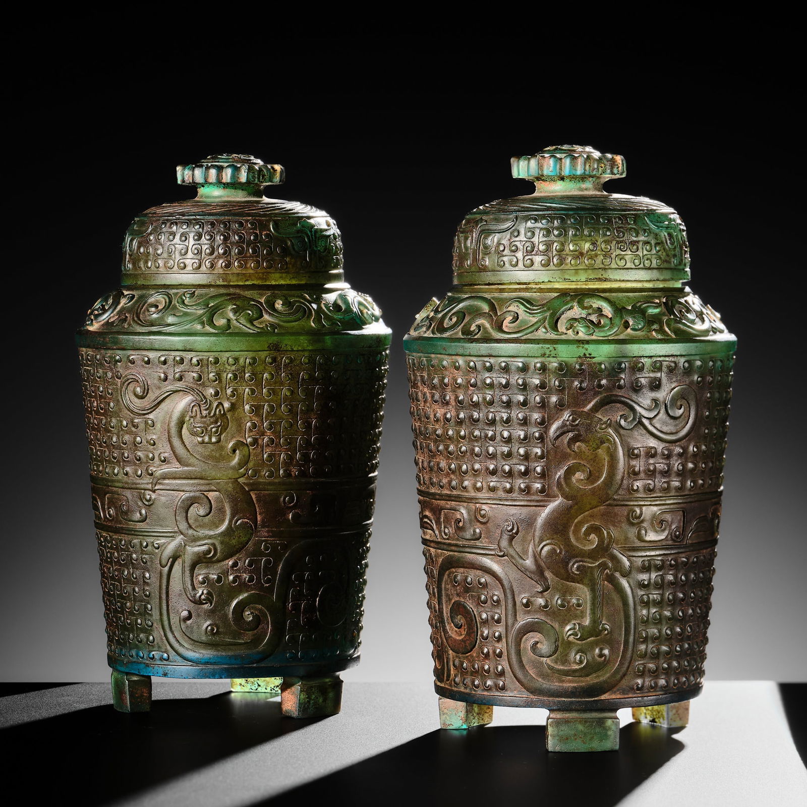 A PAIR OF GREEN GLASS 'DRAGON AND PHOENIX' JARS AND COVERS, HAN DYNASTY: A PAIR OF GREEN GLASS 'DRAGON AND PHOENIX' JARS AND COVERS, HAN DYNASTY Published: Jean-Paul Desroches (ed.) et al, The Beginning of the World. Dragons, Phoenix and Other Chimera, Fonda