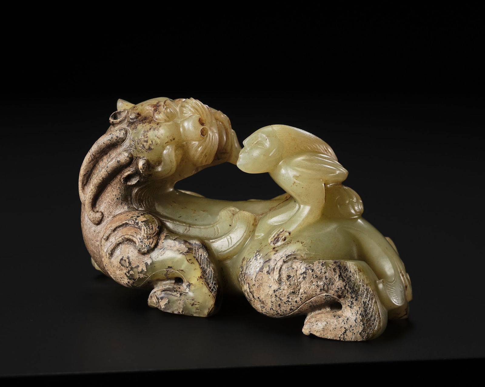 A FINE CELADON AND BROWN JADE GROUP OF AN IMMORTAL RIDING A BIXIE, HAN DYNASTY: A FINE CELADON AND BROWN JADE GROUP OF AN IMMORTAL RIDING A BIXIE, HAN DYNASTY Published: Jean-Paul Desroches (ed.) et al, The Beginning of the World. Dragons, Phoenix and Other Chimera