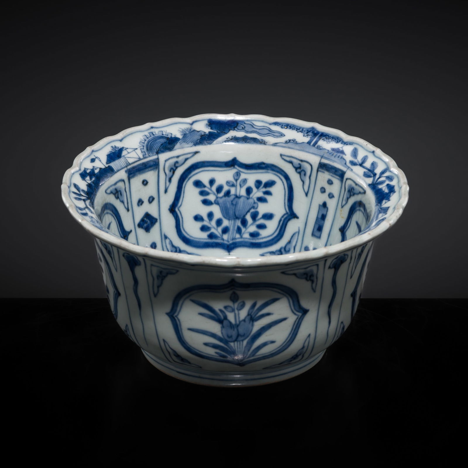 A BLUE AND WHITE 'KRAAK' PORCELAIN CHARGER, MING DYNASTY, WANLI PERIOD: A BLUE AND WHITE 'KRAAK' PORCELAIN CHARGER, MING DYNASTY, WANLI PERIOD China, 1573-1620. The deep, straight sides of the vessel supported on a slightly tapered foot with a recessed base, rising to an