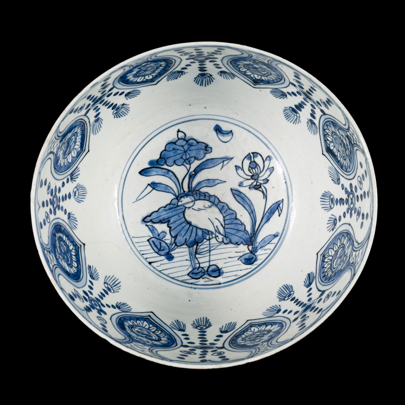 A LARGE BLUE AND WHITE 'KRAAK' PORCELAIN 'EGRET AND LOTUS' BOWL, MING DYNASTY: A LARGE BLUE AND WHITE 'KRAAK' PORCELAIN 'EGRET AND LOTUS' BOWL, MING DYNASTY China, 16th-17th century. Well-potted, with deep rounded sides rising from a short, straight foot. The interior painted