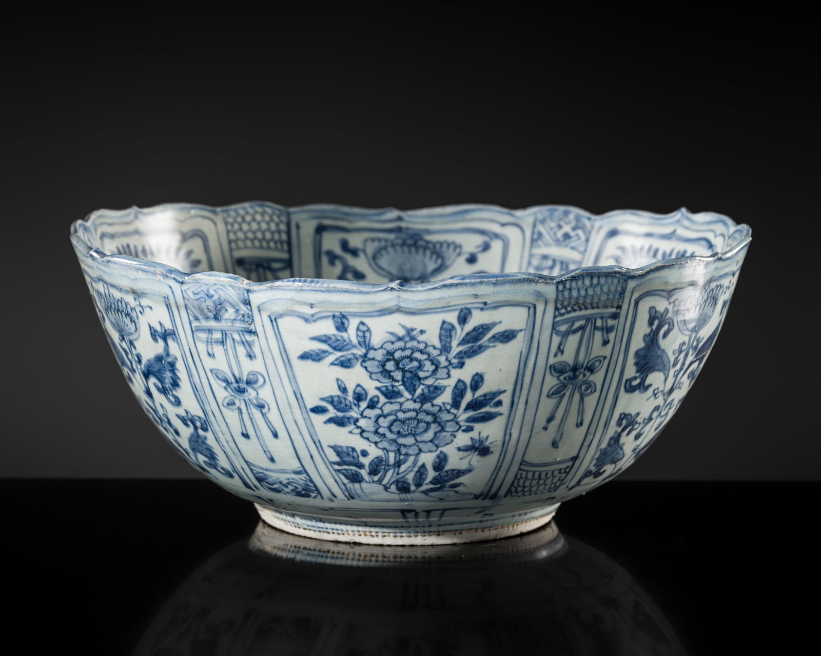 A BLUE AND WHITE 'KRAAK' BOWL, TRANSITIONAL PERIOD, FROM THE HATCHER CARGO: A BLUE AND WHITE 'KRAAK' BOWL, TRANSITIONAL PERIOD, FROM THE HATCHER CARGO China, mid-17th century. The deep rounded sides rising from a tapering foot to a barbed rim. Painted to the interior with Bu