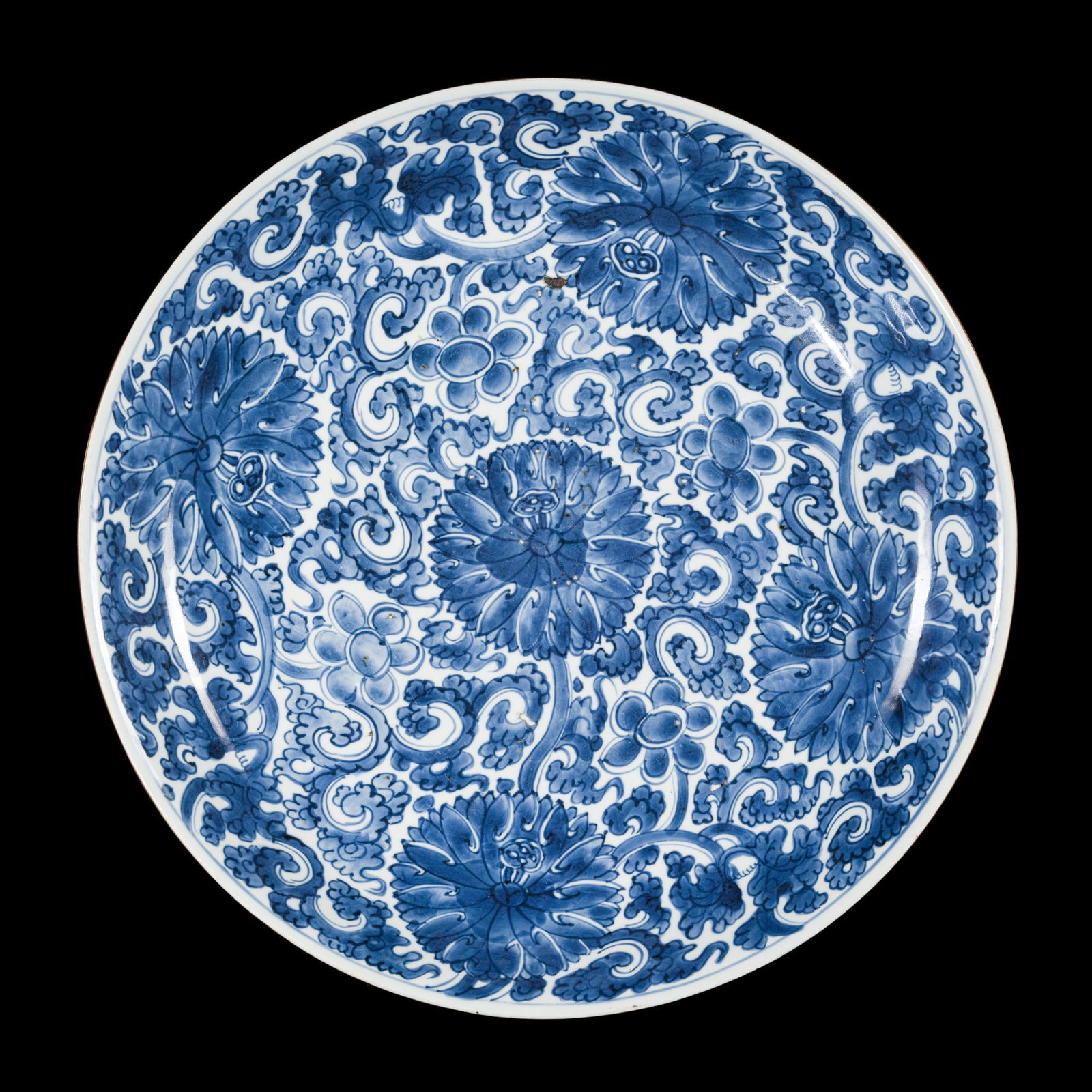 A VERY LARGE BLUE AND WHITE PORCELAIN 'PEONIES' CHARGER, QING DYNASTY, KANGXI PERIOD: A VERY LARGE BLUE AND WHITE PORCELAIN 'PEONIES' CHARGER, QING DYNASTY, KANGXI PERIOD China, 1662-1722. Well-potted, with shallow, rounded sides resting on a short, tapered foot and a gently everted r