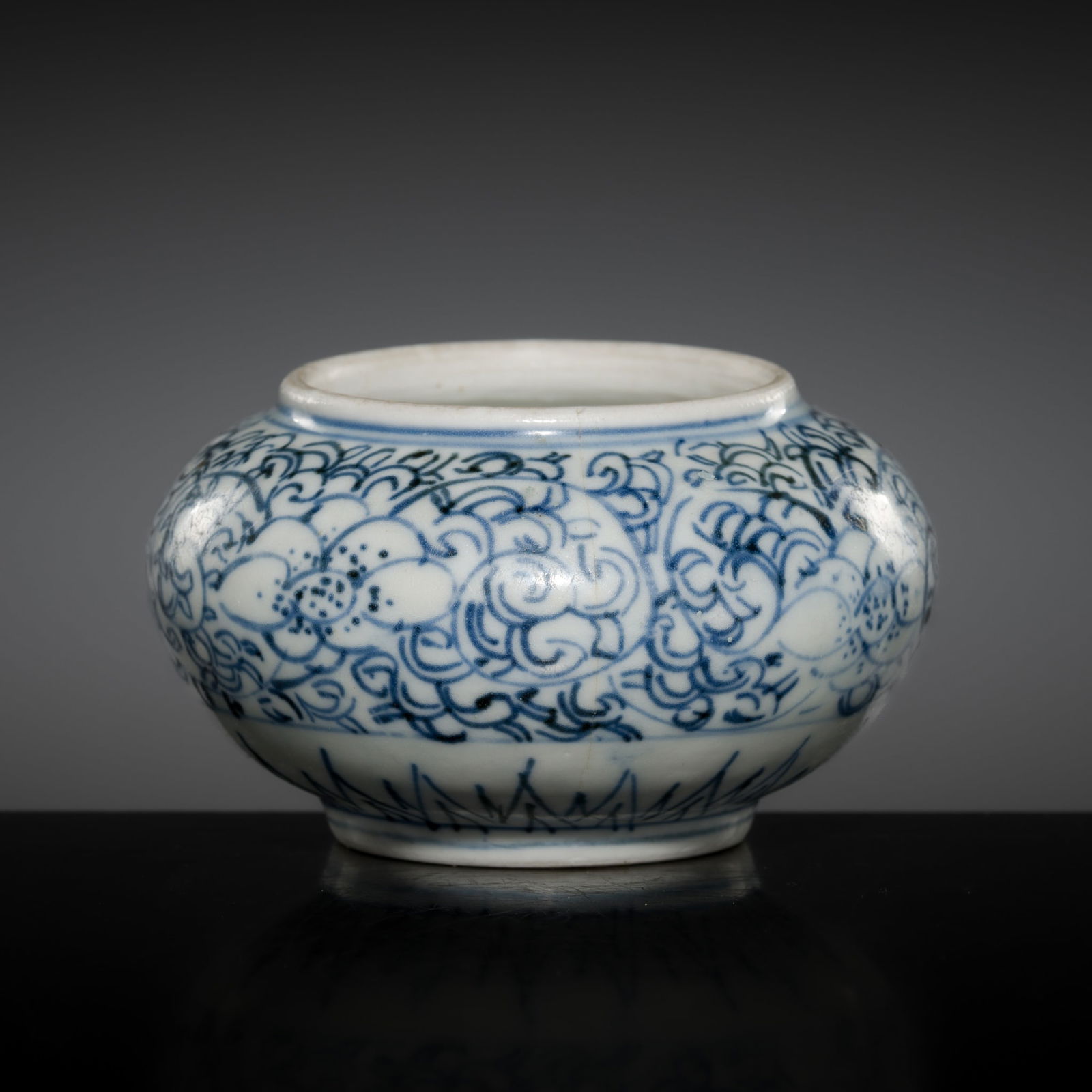 A SMALL BLUE AND WHITE PORCELAIN 'LOTUS' WATER POT, EARLY QING DYNASTY: A SMALL BLUE AND WHITE PORCELAIN 'LOTUS' WATER POT, EARLY QING DYNASTY China, 17th-18th century. Well-potted, the globular body supported on a short foot with a recessed base, rising to a broad circu