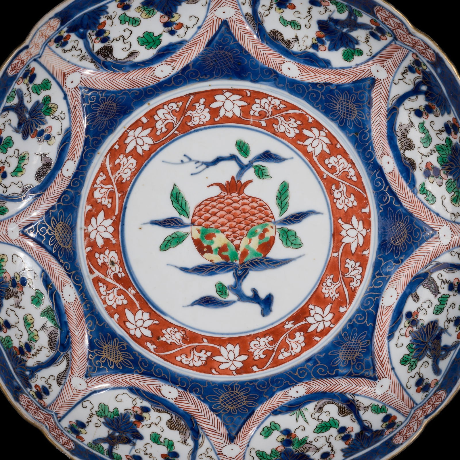 A LARGE WUCAI BARBED RIM DISH WITH POMEGRANATE AND GRAPEVINES, 18TH CENTURY: A LARGE WUCAI BARBED RIM DISH WITH POMEGRANATE AND GRAPEVINES, 18TH CENTURY China. Finely potted with deep, rounded sides, supported on a short, slightly tapered foot, rising to a gently curved, lobe