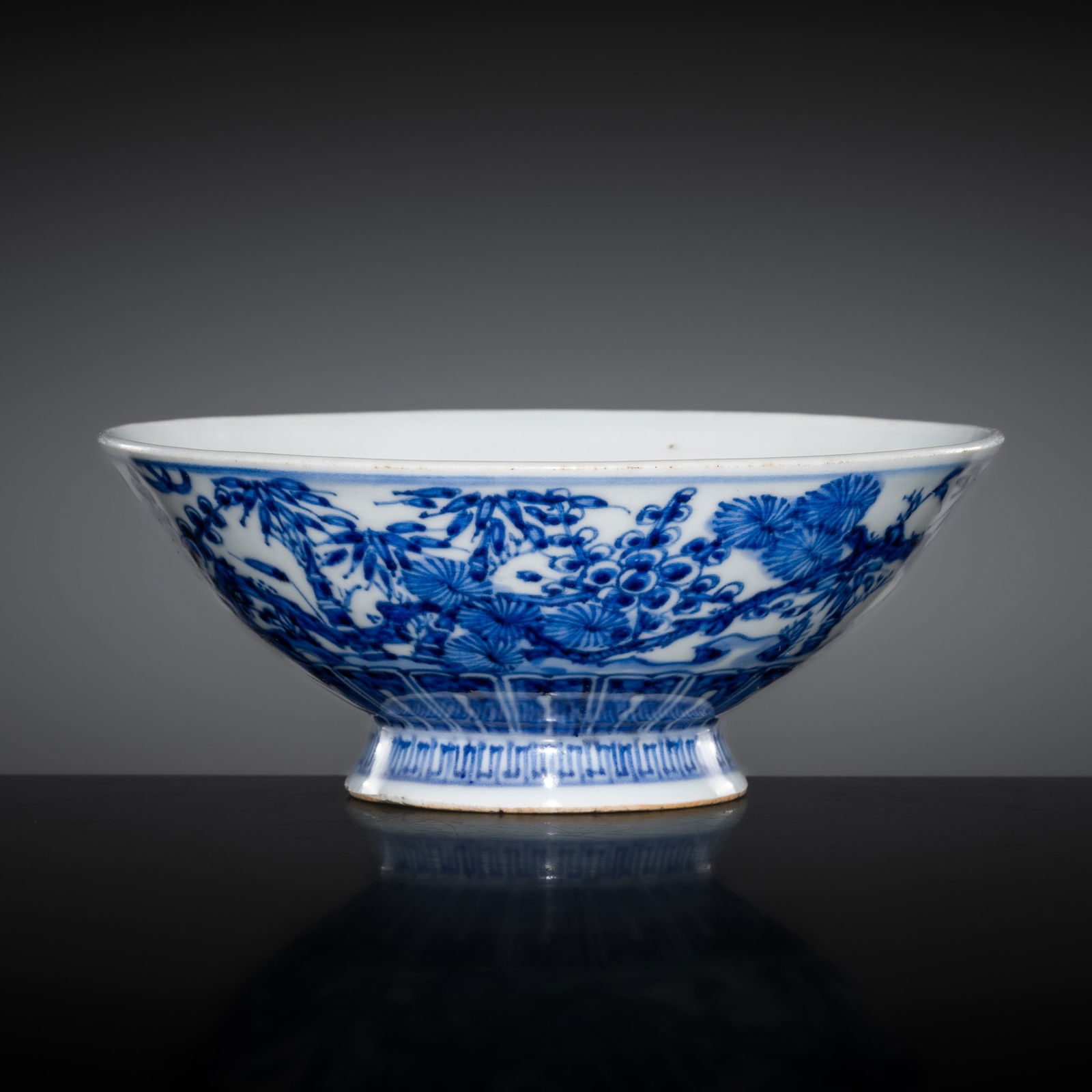 AN AUSPICIOUS BLUE AND WHITE PORCELAIN 'THREE FRIENDS OF WINTER' BOWL, QING DYNASTY: AN AUSPICIOUS BLUE AND WHITE PORCELAIN 'THREE FRIENDS OF WINTER' BOWL, QING DYNASTY China, 18th-19th century. Finely potted with deep, subtly concave sides supported on a splayed foot with a recessed