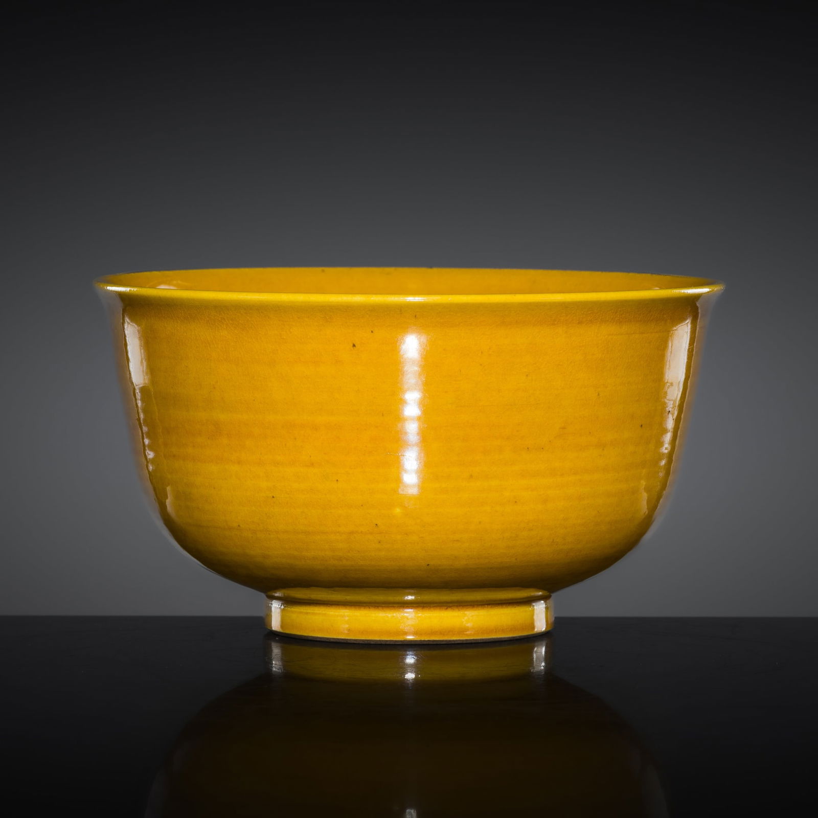 A FINE YELLOW-GLAZED PORCELAIN BOWL, QING DYNASTY: A FINE YELLOW-GLAZED PORCELAIN BOWL, QING DYNASTY China, 18th-19th century. Superbly potted with deep, rounded sides, exhibiting pronounced horizontal pottery marks along the body,