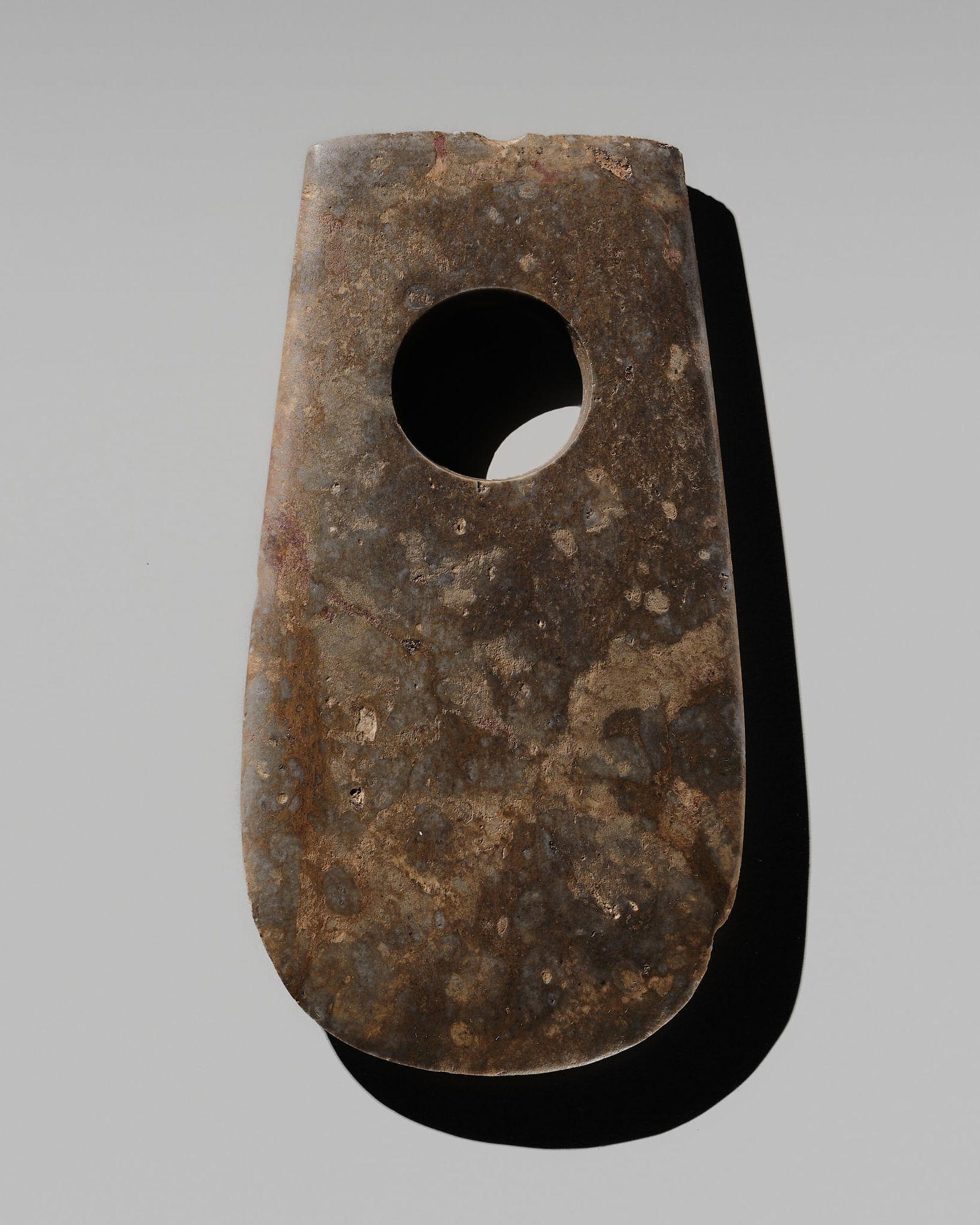 A MOTTLED BROWN STONE AXE, NEOLITHIC, SONGZE OR LIANGZHU CULTURE: A MOTTLED BROWN STONE AXE, NEOLITHIC, SONGZE OR LIANGZHU CULTURE Published: Myers Myers (ed.) & Filippo Salviati (auth.), Radiant Stones. Archaic Chinese Jades, Paris, 2000, no. 24.