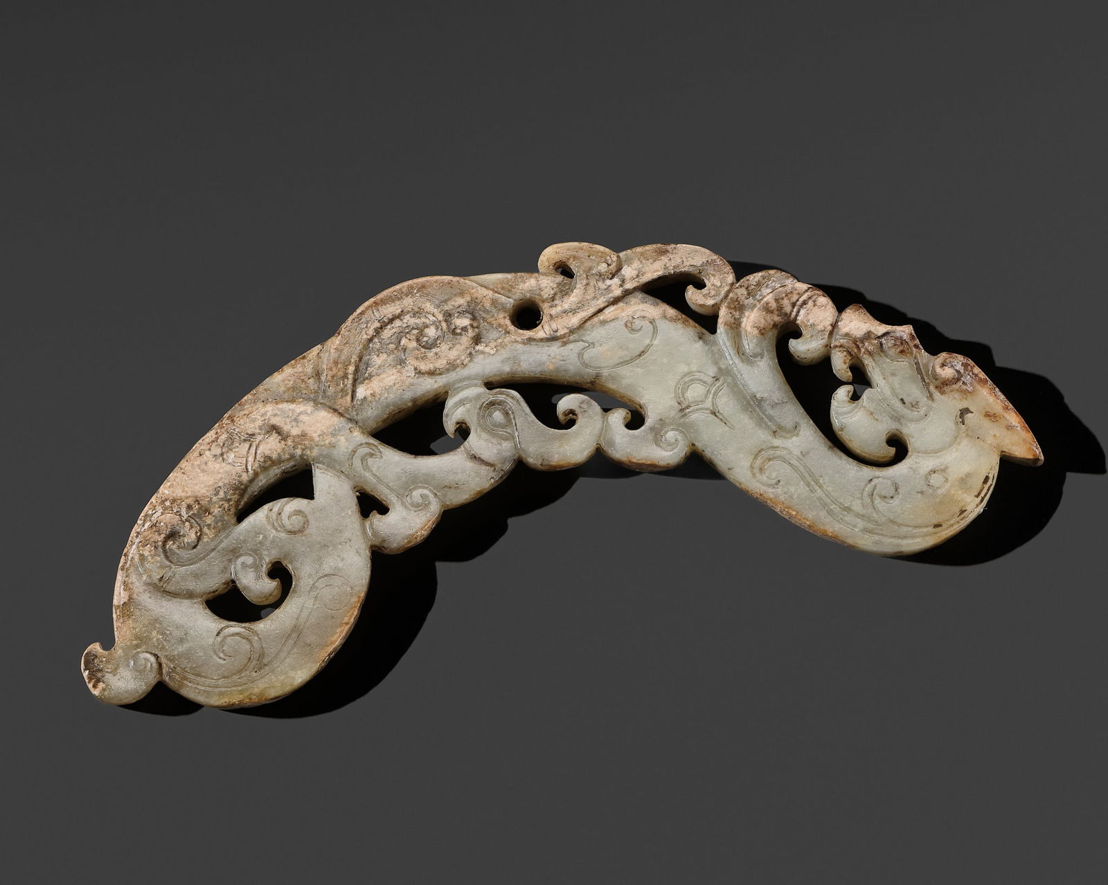 A GREEN JADE 'PHOENIX AND DRAGON' OPENWORK PENDANT, EASTERN ZHOU PERIOD (1 of 15)