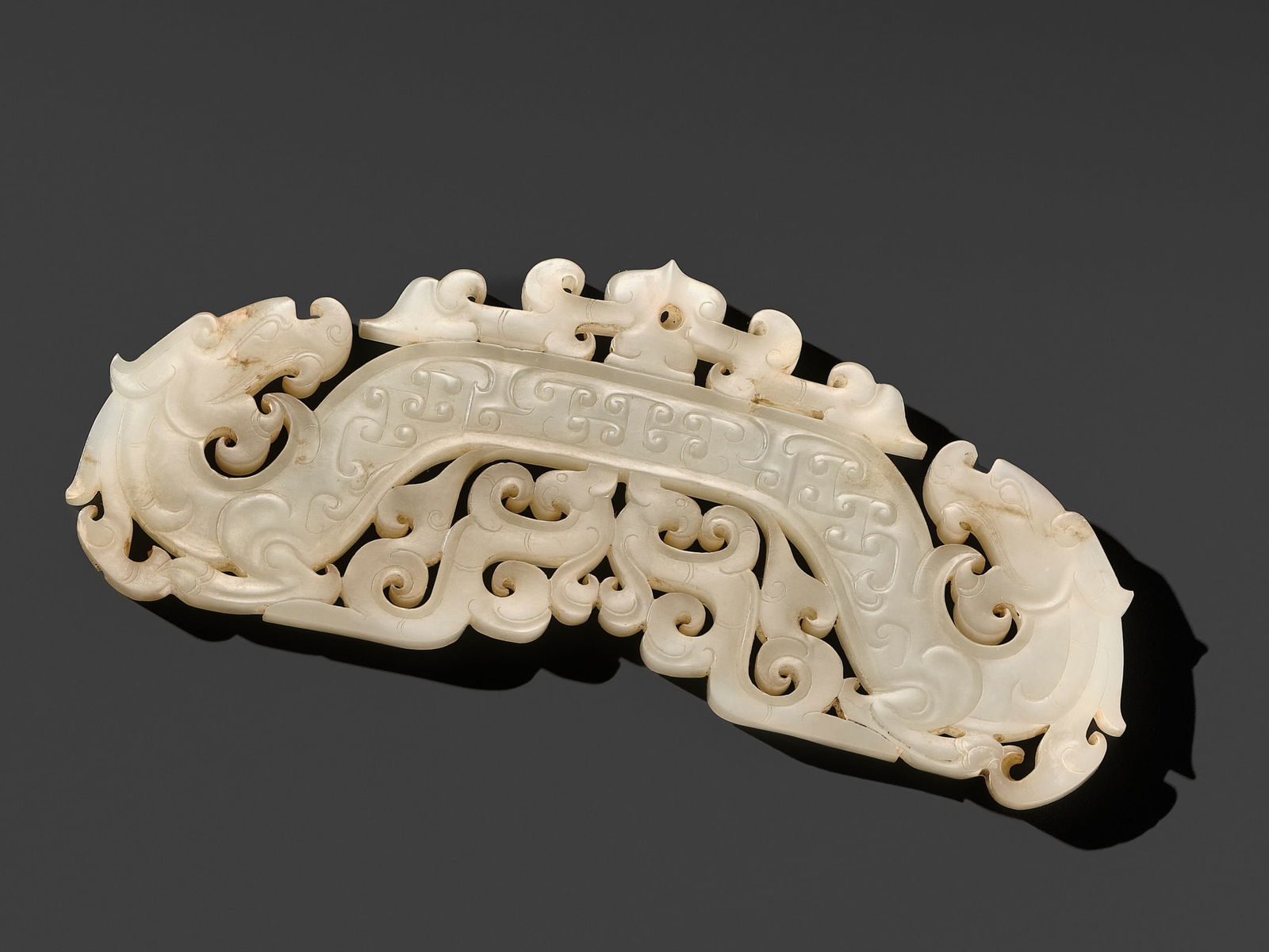 A WHITE AND RUSSET JADE PENDANT, HUANG, LATE EASTERN ZHOU PERIOD (1 of 16)
