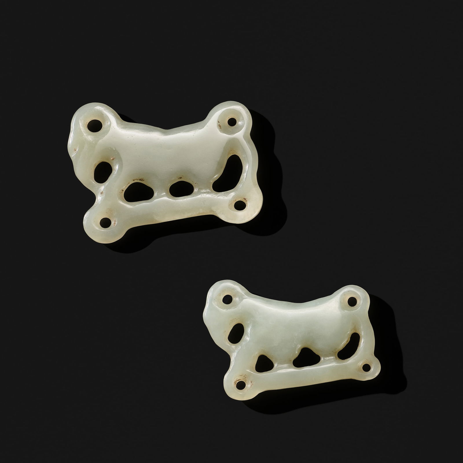 AN EXCEEDINGLY RARE PAIR OF WHITE JADE 'STAG' PLAQUES: AN EXCEEDINGLY RARE PAIR OF WHITE JADE 'STAG' PLAQUES Northern China or Inner Mongolia, Ordos, c. 6th-2nd century BC. Each finely carved in openwork as a highly stylized stag shown in profile, with i