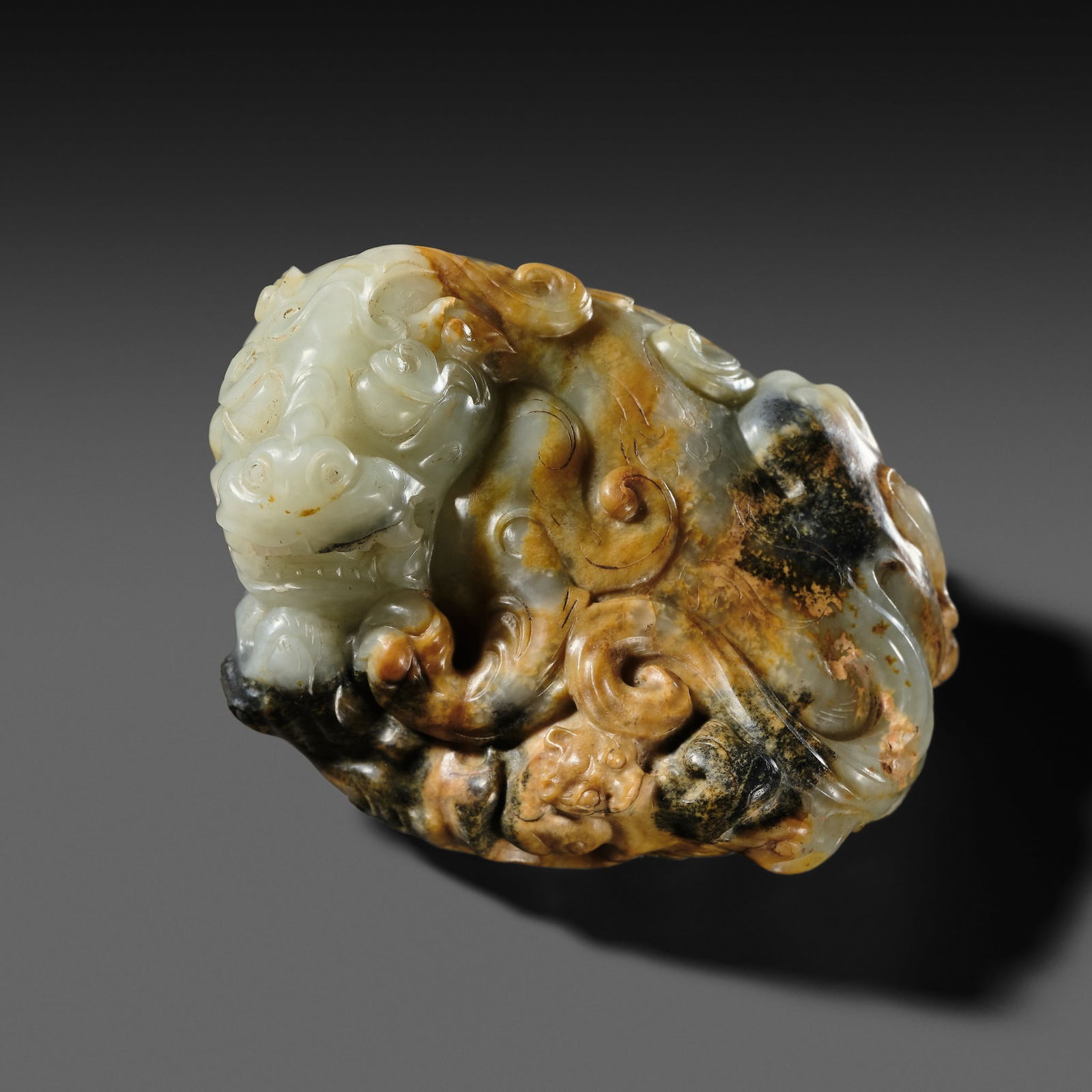 A WHITE AND RUSSET JADE 'LION' WEIGHT, HAN DYNASTY (1 of 15)